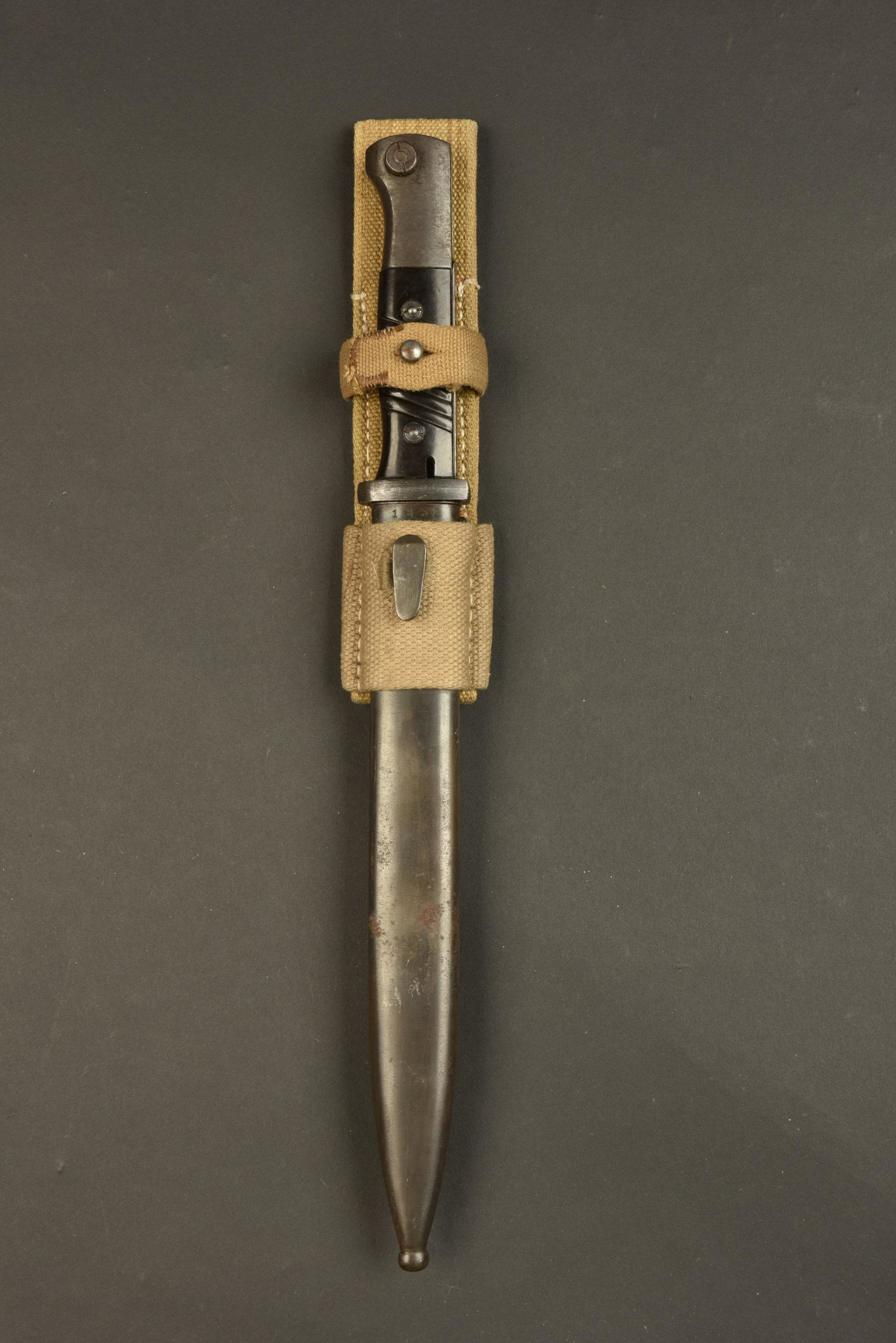 Baionnette 98K. 98K Bayonet: Baionnette 98K. Plaquettes en bakelite noire. Lame dans sa couleur d origine a 90%. Numero 1832d, fabrication 43CRS. Fourreau en metal, presentant quelques traces d oxydation. Numero 1832d, fabricatio
