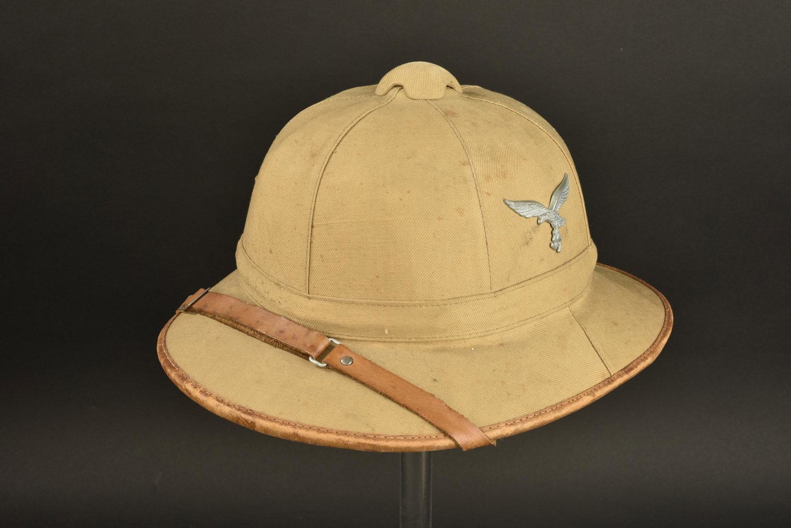 Casque tropical LW. Luftwaffe tropical helmet: Casque tropical Luftwaffe. Premier modele en toile couleur sable. Insignes metalliques. Les insignes n ont pas ete demontees afin de verifier les attaches de fixation. Jugulaires en cuir complete, cou