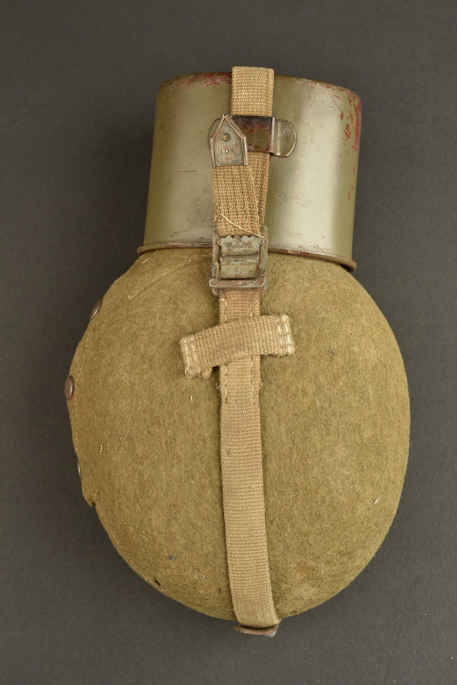 Gourde allemande. German Canteen: Gourde allemande. Gourde en aluminium, fabrication VDNS 41. Bouchons en bakelite complet. Housse en feutrine, les boutons pressions sont fonctionnels. Harnais en toile sable complet, mousqueton bien m