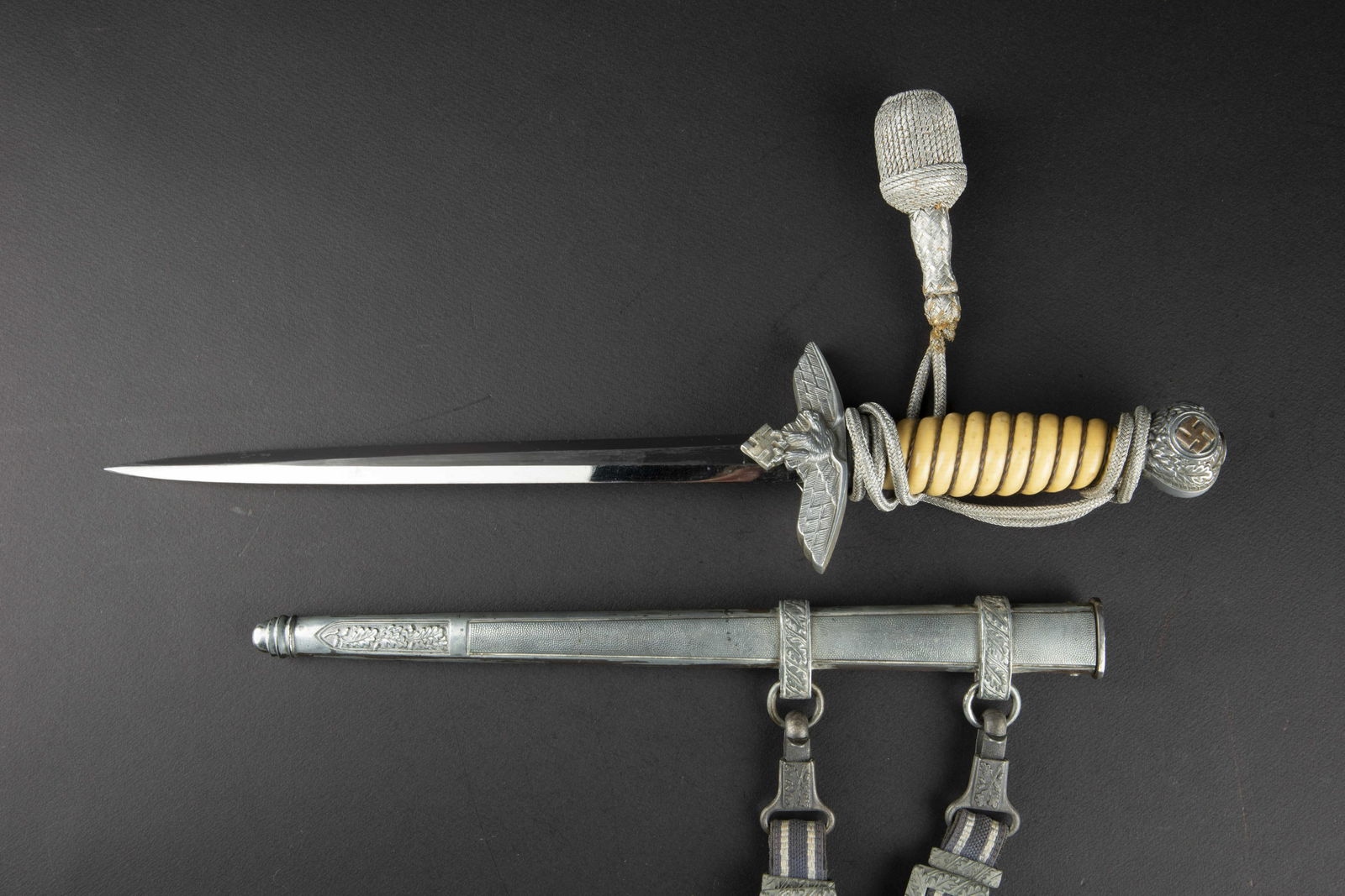 Dague 37 LW. Luftwaffe dagger: Dague 37 Luftwaffe. Garniture en alliage d aluminium. Les insignes nationaux du pommeau disposent de quelques traces de dorure. Garde avec aigle et dos grenele. Fusee de couleur blanche, legerement ta