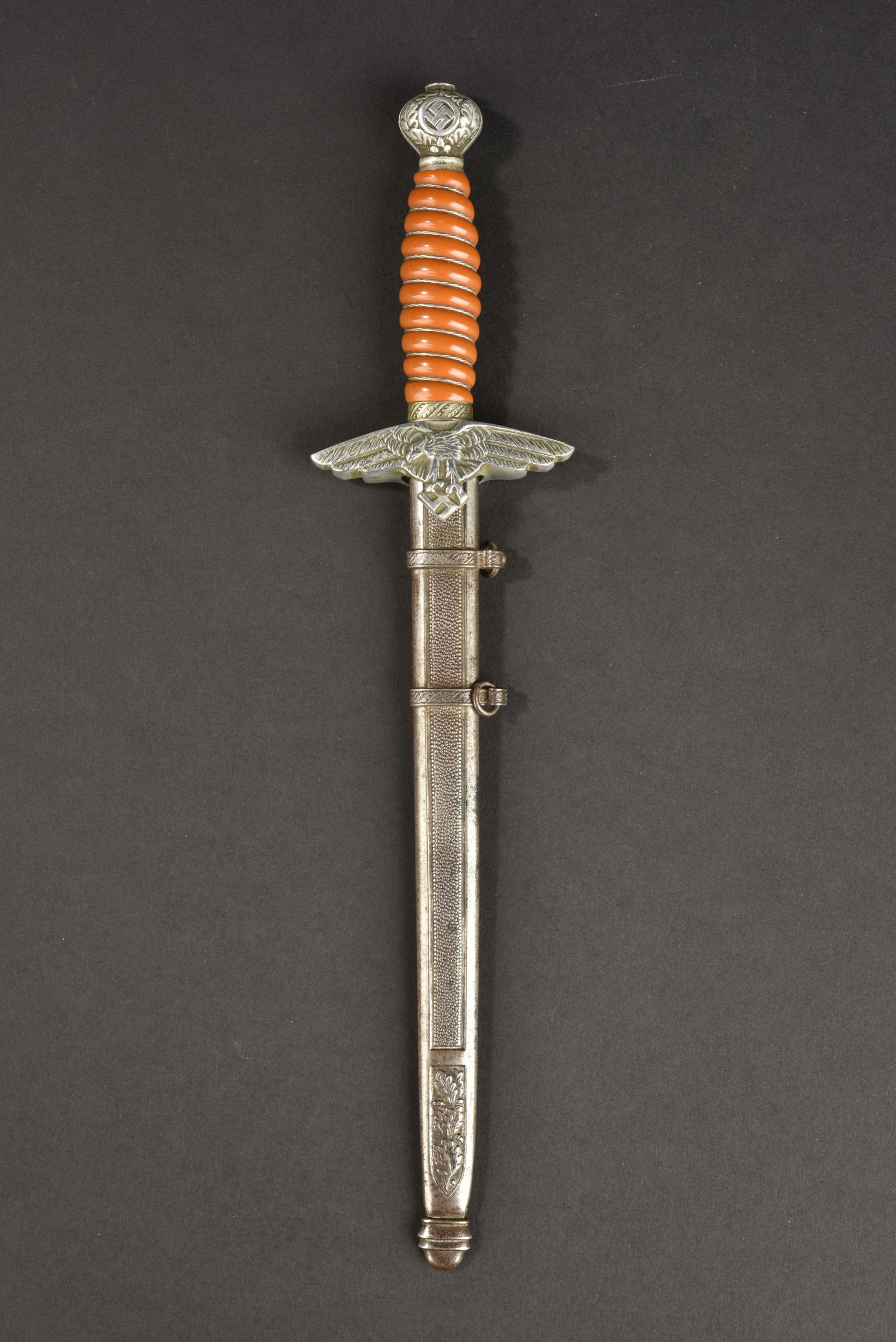 Miniature dague officier LW. Miniature LW officer dagger.: Miniature dague officier Luftwaffe. Modele de presentation pour les fabricants de dague. Garnitures en metal, poignee de couleur orange, filigrane present. Belle lame sans marquages fabricant. Fourrea