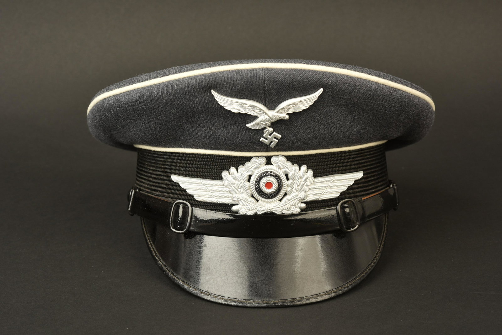 Casquette NCO Hermann Goering. Hermann Goering cap: Casquette de sous-officier Hermann Goering. En gabardine gris/bleu. Les insignes sont metalliques et n ont pas ete demontes afin de verifier les attaches. Bandeau en mohair noir. Triple lisere blanc. 