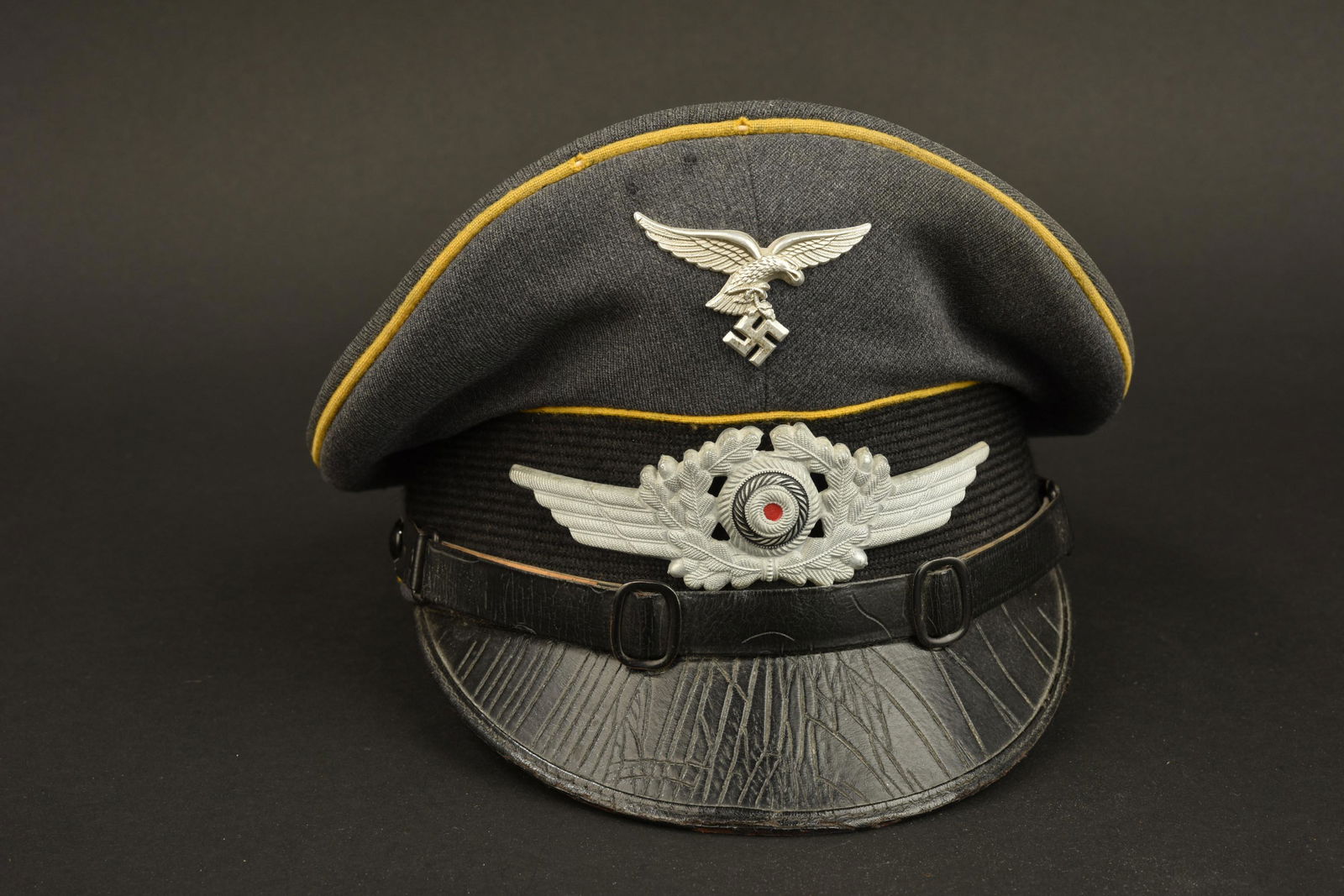 Casquette Luftwaffe. Luftwaffe cap: Casquette Luftwaffe. Modele pour sous-officier du personnel volant ou parachutiste. Coiffe en gabardine gris/bleu. Aigle de la Luftwaffe du premier type, petit modele. Cocarde et feuilles de chene, pr