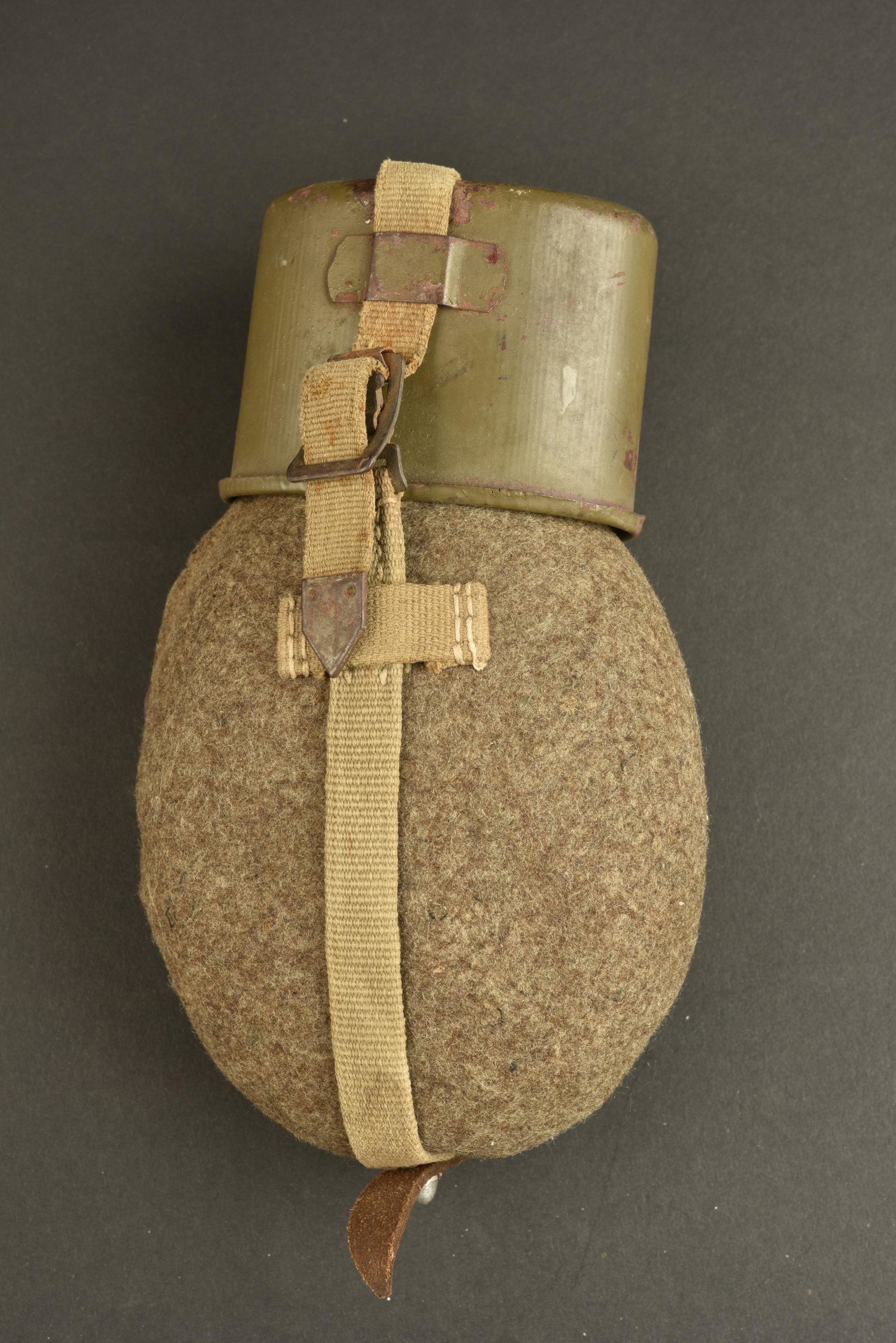 Gourde allemande. German canteen: Gourde allemande. Gourde aluminium DMN 43. Bouchon en bakelite complet. Housse en feutrine, tous les boutons pressions sont fonctionnelles. Harnais en toile complet, mousqueton present. Quart en metal