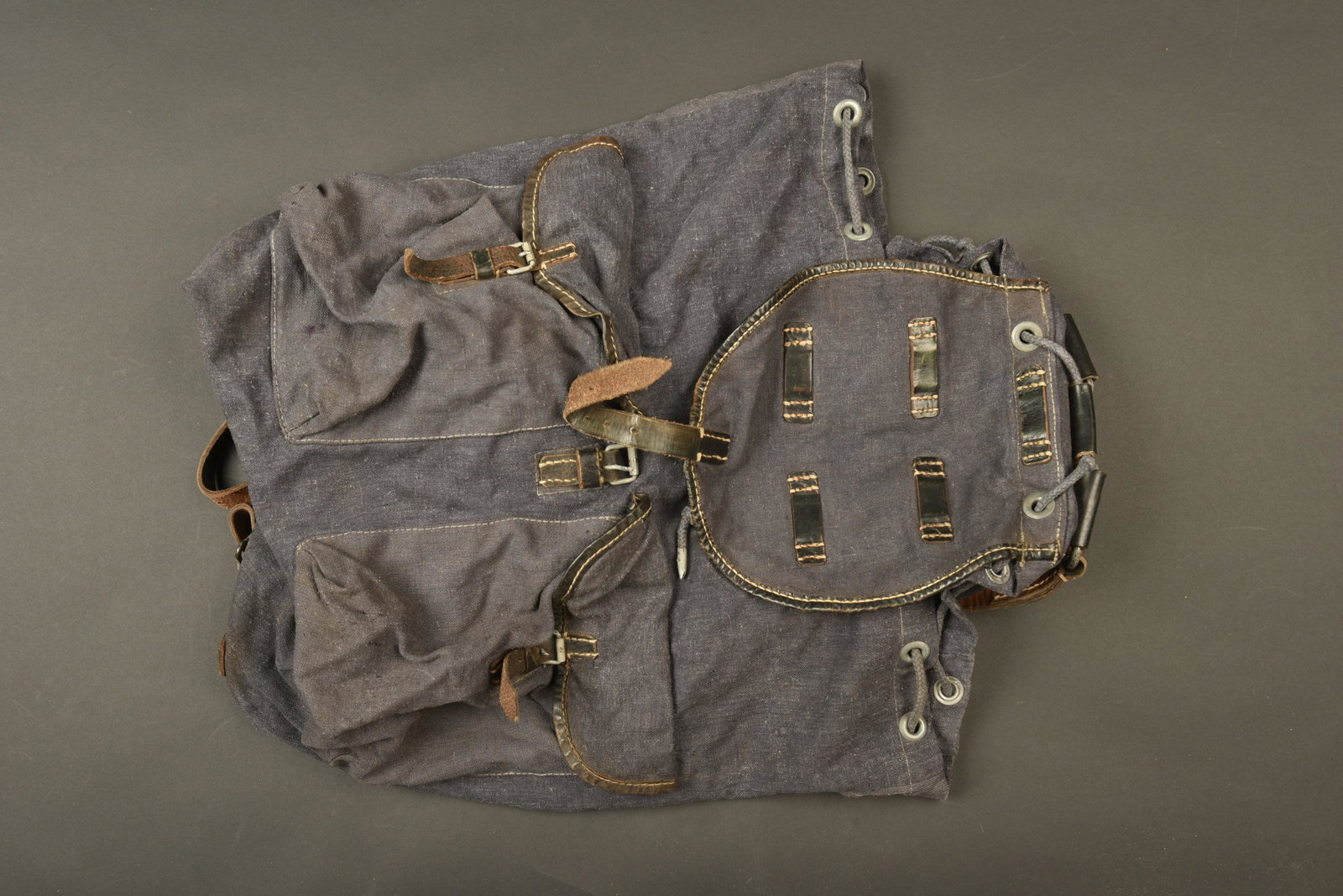 Sac a dos Luftwaffe. Luftwaffe rucksack: Sac a dos de la Luftwaffe. En forte toile gris/bleu et cuir noir. La majorite des sangles sont presentes. Cordon de serrage present. Les bretelles sont completes. Toutes les pieces metalliques sont pr