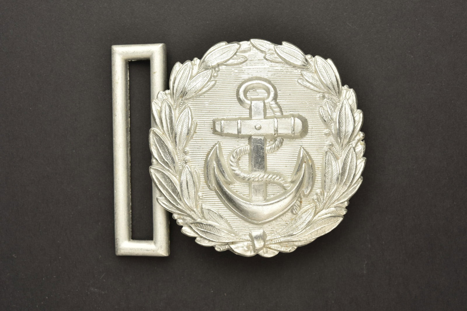 Boucle administration KM. KM Belt buckle: Boucle administration Kriegsmarine. En aluminium, couleur argent. Sans marquages visibles. A noter une certaine usure et patine de la piece. Etat II+. Kriegsmarine administration loop. Aluminum, silve