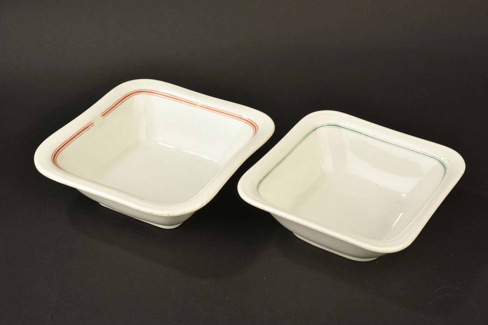 Plats Kriegsmarine. Dishes Kriegsmarine.: Plats de la Kriegsmarine. Comprenant un plat carre, en porcelaine blanche, lisere vert du mess des officiers, longueur 22 cm, fabrication KPM 1941. Un plat en porcelaine blanche, lisere rouge du mess