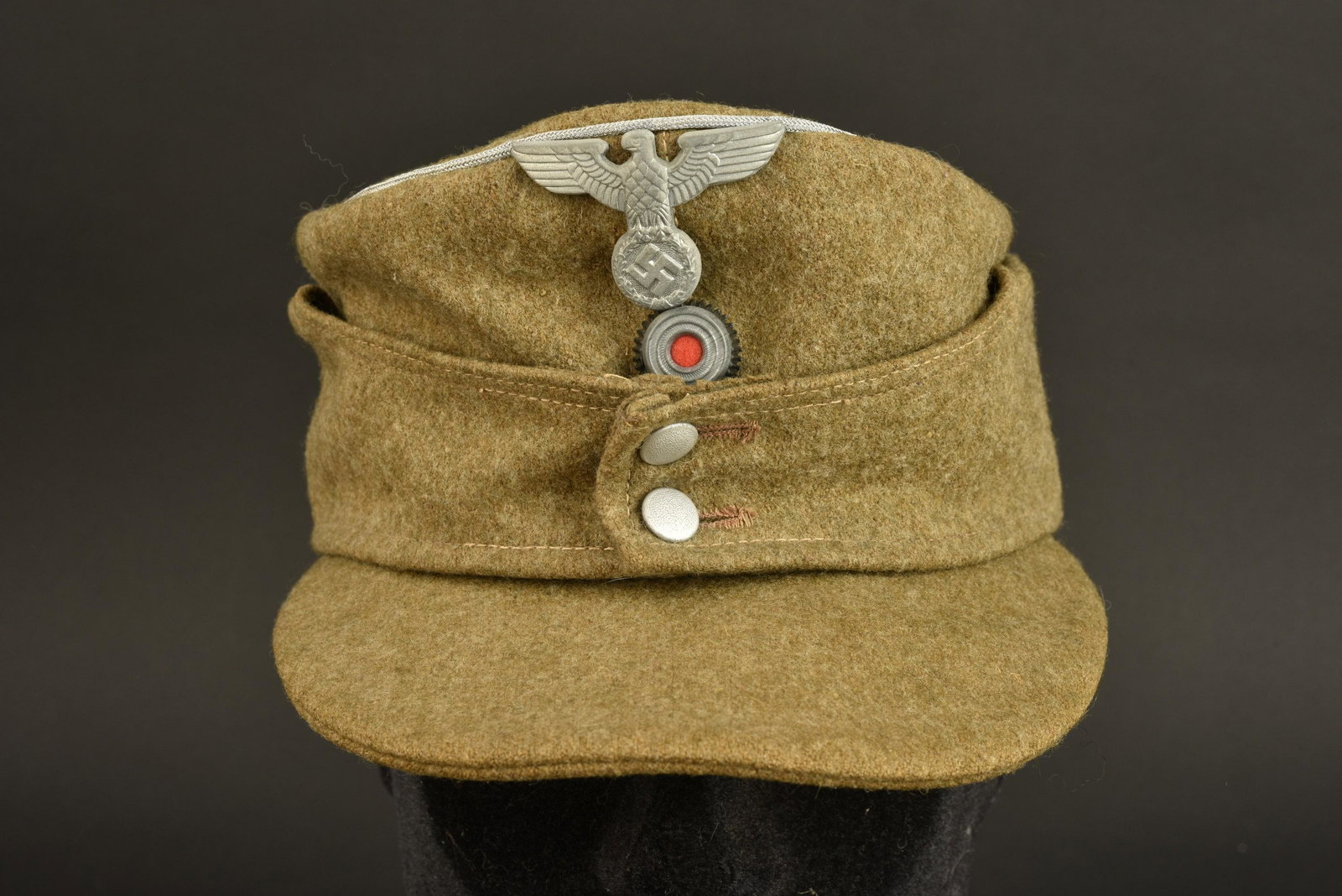 Casquette organisation Todt. Todt cap: Casquette organisation Todt. En drap kaki, lisere argent faisant le tour de la coiffure. Cocarde metallique. Aigle metallique du type politique. Les insignes n ont pas ete demontes, afin de verifier l