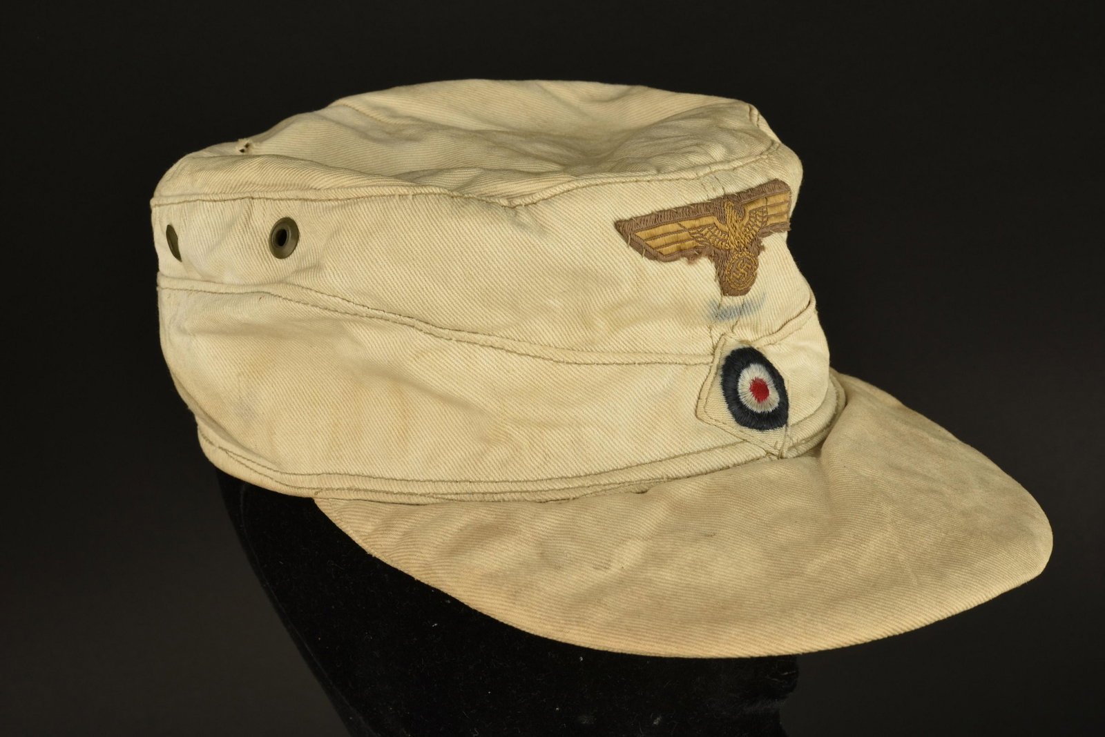 Casquette M-43 KM. Kriegsmarine cap: Casquette M-43 Kriegsmarine. Fabrication francaise. En toile sable. Aigle de la Kriegsmarine Bevo, monte main. Cocarde brode sur fond blanc, montee machine. Doublure en carton de la visiere est fortem