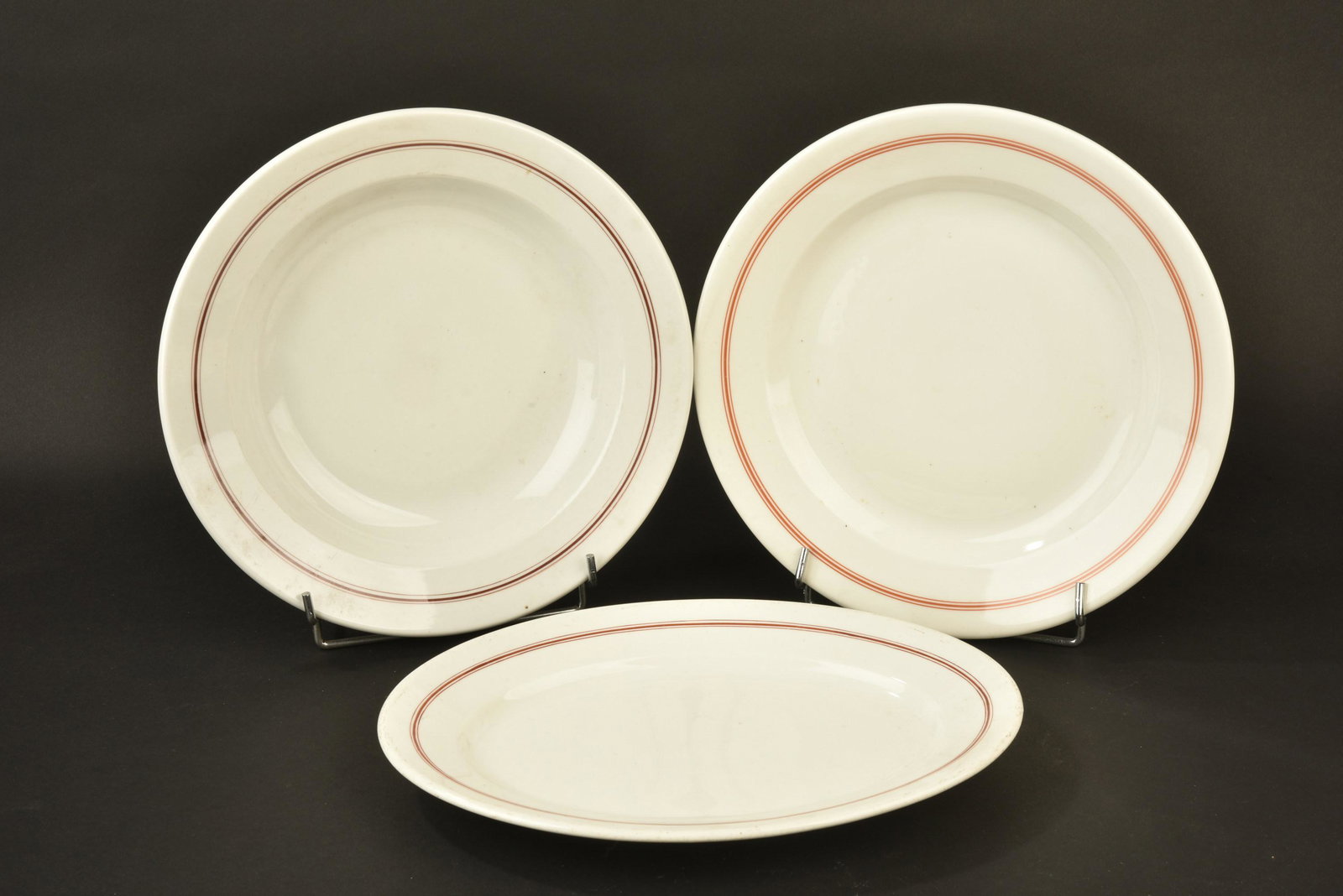 Plats Kriegsmarine. Kriegsmarine dishes.: Plats de la Kriegsmarine. Comprenant un plat ovale, lisere rouge du mess des sous-officier, longueur 33 cm, fabrication KPM 1941. Un plat en porcelaine blanche, lisere rouge du mess des sous-officier,