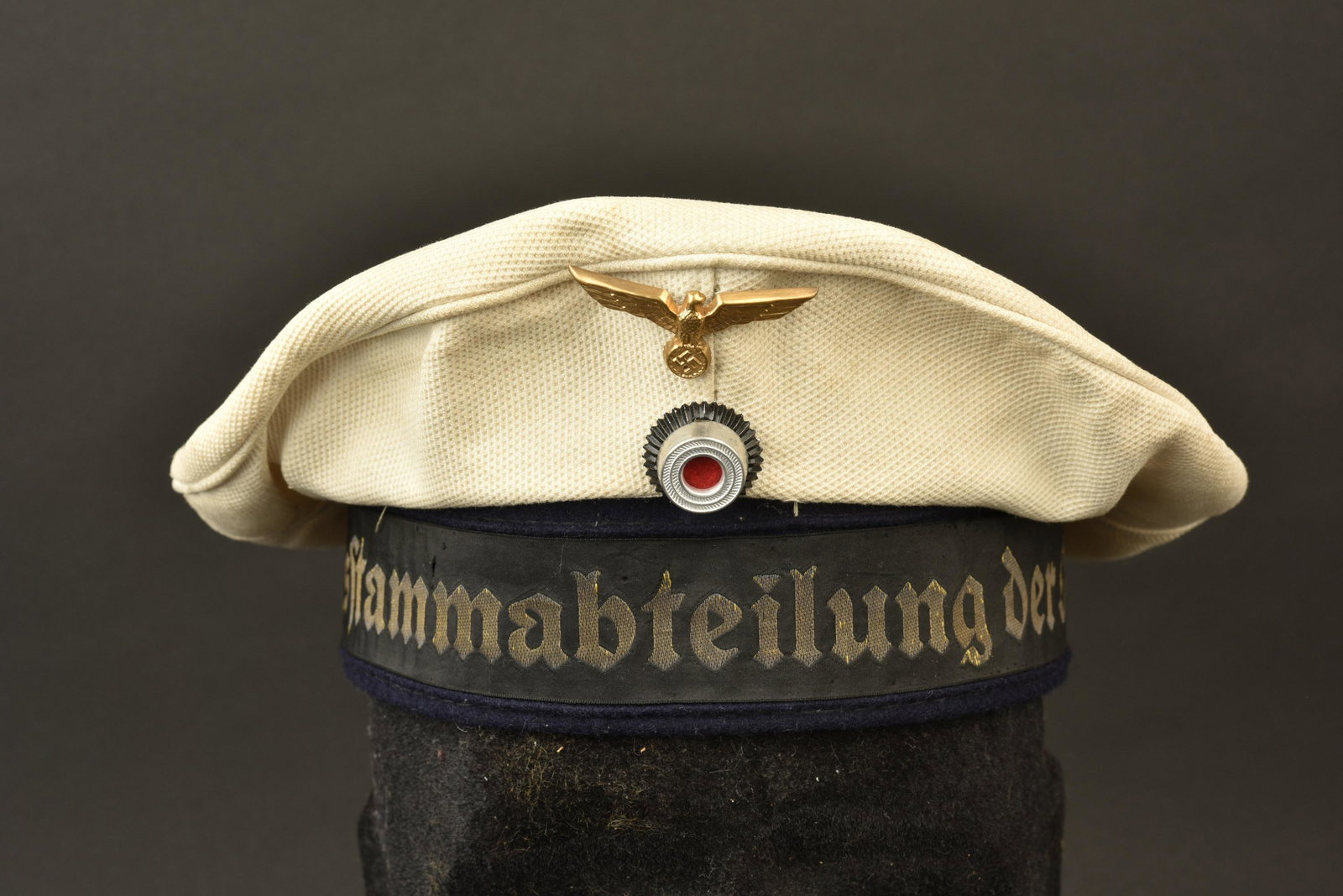 Bachi Kriegsmarine. Kriegsmarine cap: Bachi de la Kriegsmarine. Coiffe en tissu nid d abeille blanc. Insignes metallique en deux parties. Les insignes n ont pas ete demontes afin de verifier les pattes de fixation. Bande de bachi marquee 