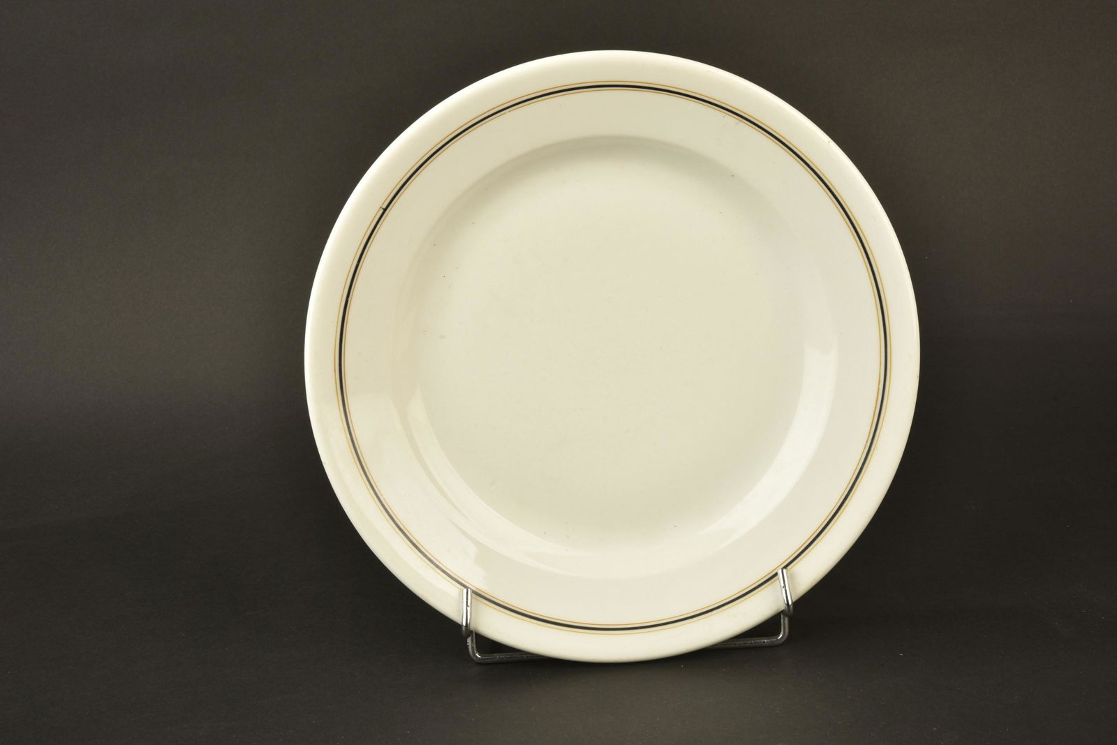 Plat amiraute Kriegsmarine. Admiralty dish Kriegsmarine.: Plat de l amiraute Kriegsmarine. En porcelaine blanche, lisere noir et or de l amiraute. Diametre 30 cm. Fabrication Koenigszelt 1942. A noter une certaine usure et patine de la piece. Etat II+. Cette