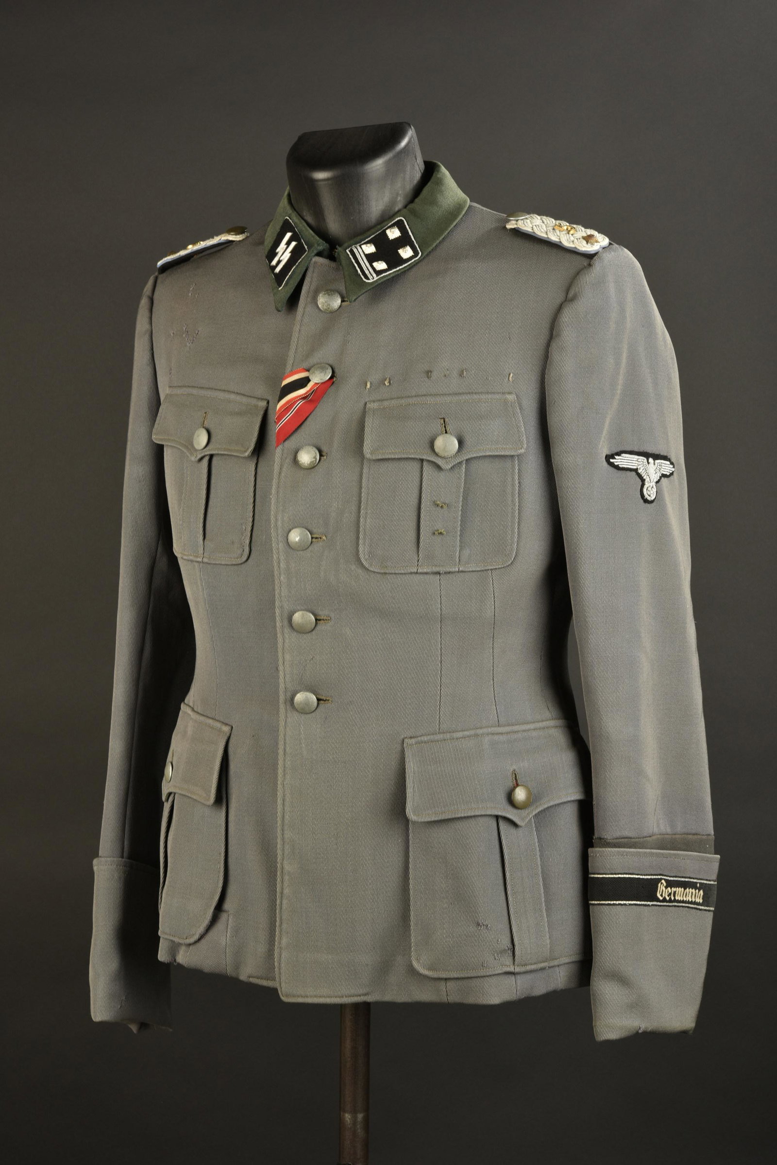 Vareuse officier SS. SS officer jacket: Vareuse officier SS. En gabardine kaki, tous les boutons sont presents. Col en tissu vert canard. Pattes de col d officier SS, grade d Obersturmbahnnfuhrer, montes machine. Patte d epaule homogene d O