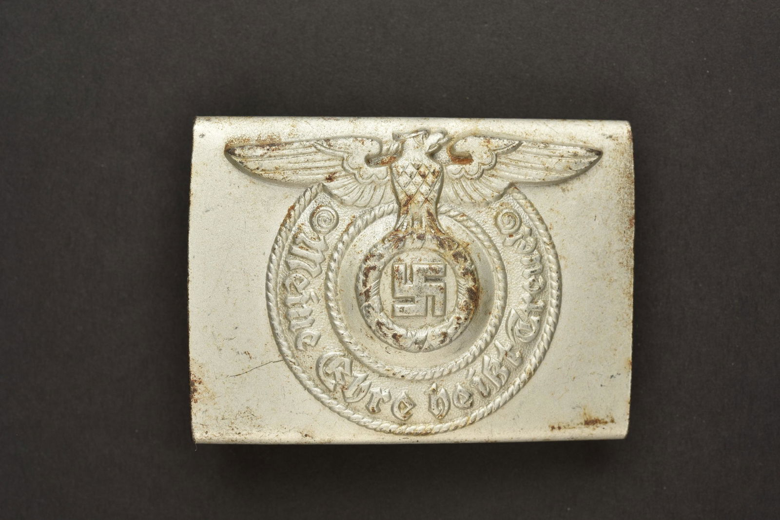 Boucle de ceinturon SS. SS Belt buckle: Boucle de ceinturon SS. En metal, couleur argent, ardillons manquants. Fabrication RZM SS 155/40. A noter une certaine usure et patine de la piece. Collection Thierry Juif Rosebud. Etat II+. SS belt b