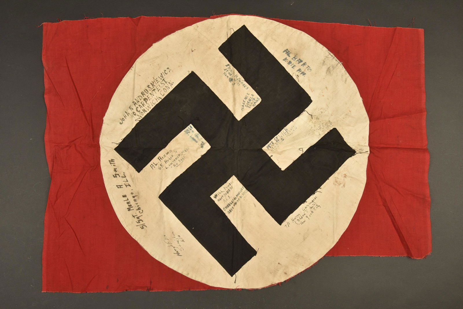 Drapeau allemand signe par des veterans US. German flag signed by US veterans.: Drapeau allemand signe par des veterans US. Drapeau en tissu coton rouge, incomplet, decoupe. Insigne national tisse et rapporte, biface. Nombreuses signature de veterans US. Alberto E Rie PH, Pete Se