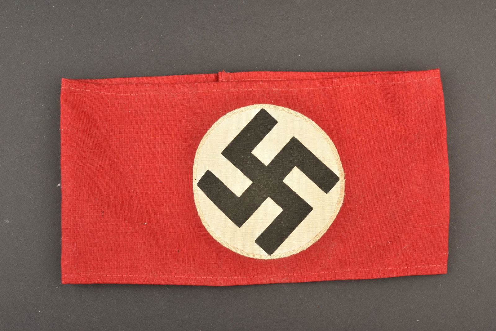 Brassard allemand. German armband: Brassard allemand. En tissu coton rouge. Insigne national imprime. Deux tampons presents mais illisibles. A noter une certaine usure et patine de la piece. Etat II+. German armband. In red cotton fabr