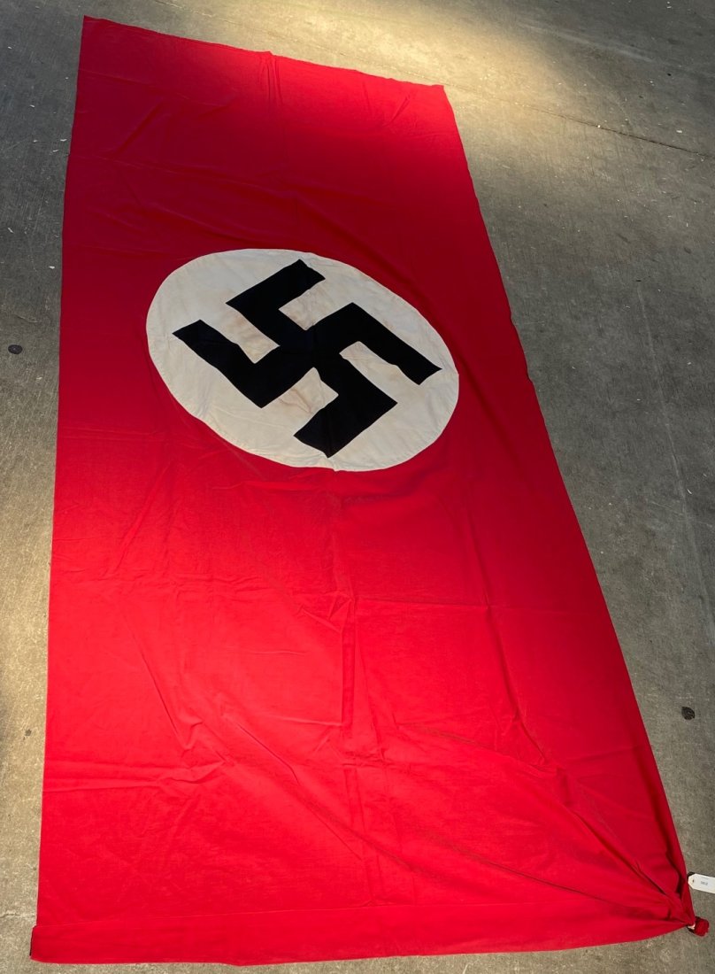 Drapeau allemand. German flag: Drapeau allemand. En tissu coton rouge, insignes nationaux rapportes. Dimensions 150 x 215 cm. A noter une certaine usure et patine de la piece, ainsi que quelques taches et accrocs. Etat II+. German