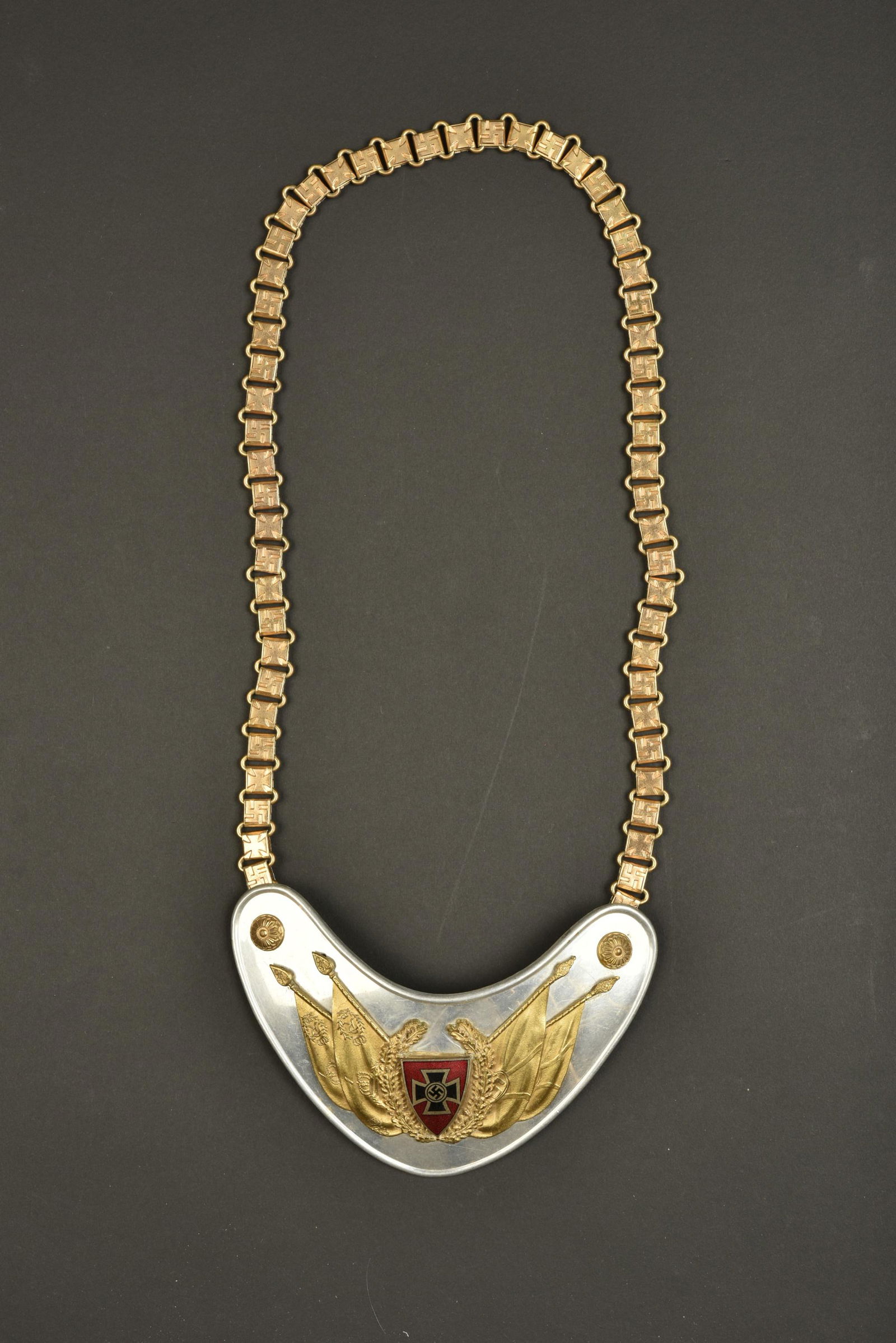 Hausse col anciens combattants. Veterans gorget: Hausse col anciens combattants. Plaque en aluminium. Insigne rapporte du NSRKB. Les deux boutons en metal dores sont presents. Chainette complete, alternant un insigne national allemand et une croix d