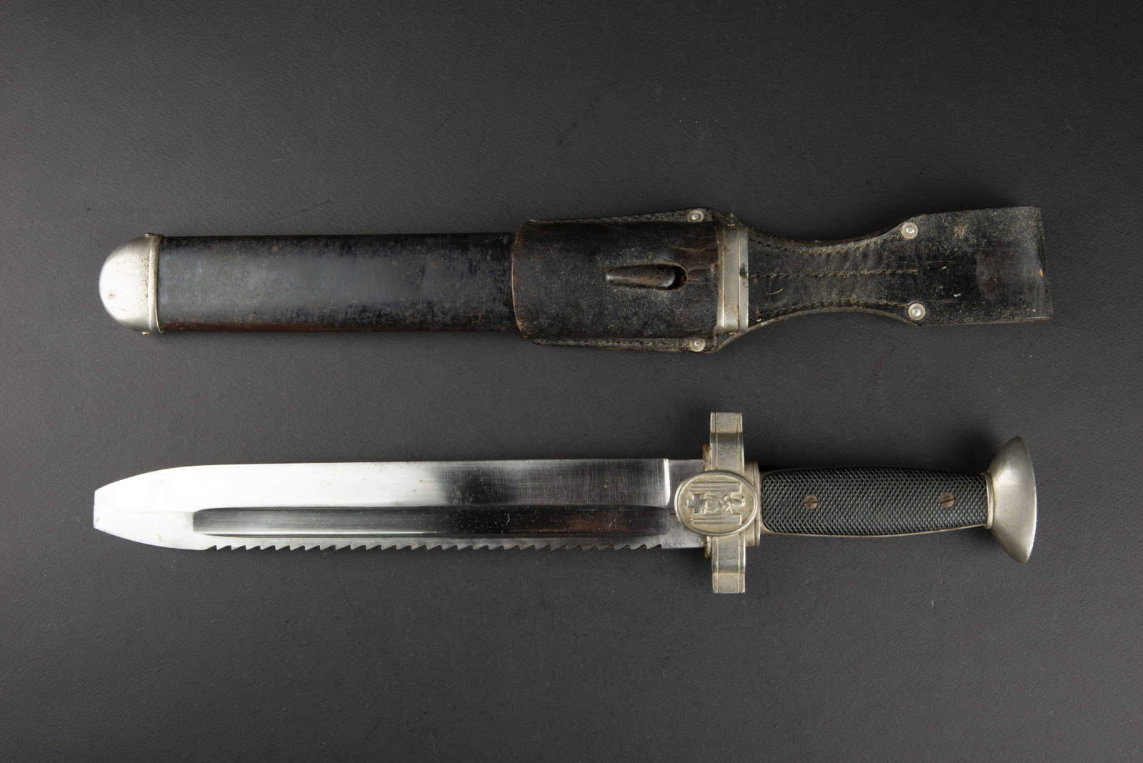 Fendoir DRK. DRK Dagger: Fendoir DRK. Les garnitures metalliques sont de couleur nickele. Les plaquettes en bakelite sont presentes. Une est grenele, la seconde est lisse. Plaquette arriere fendue. L'insigne national est en t