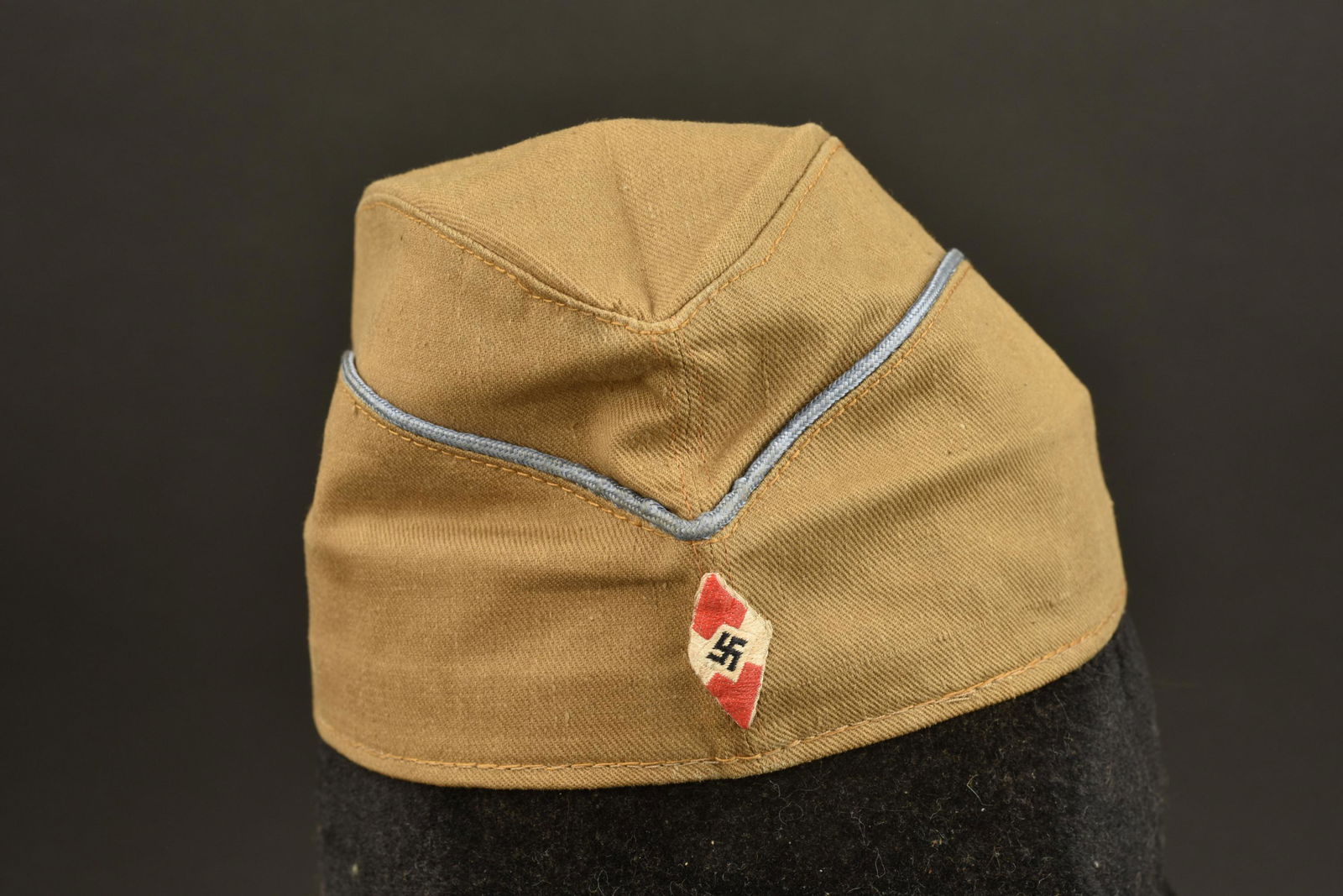 Calot HJ. Hitlerjugend cap: Calot Hitlerjugend. En toile cachou. Lisere bleu faisant le tour de la coiffe. Insigne HJ tisse monte main. Interieur double en tissu coton cachou. Taille 53. Bandeau de transpiration en faux cuir mar