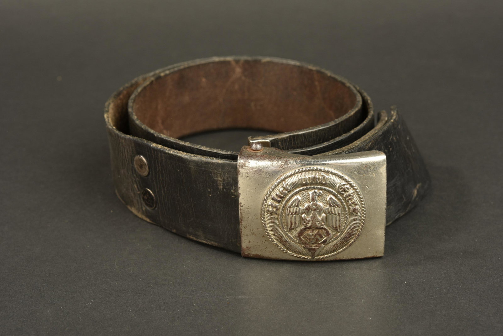 Ceinturon HJ. Hitlerjugend belt: Ceinturon Hitlerjugend. Ceinturon en cuir noir. Deux rivets maintiennent la patte de reglage. Sans marquages visibles. Boucle en metal, chrome. Chrome present a 60%. Marquages RZM illisibles. A noter 
