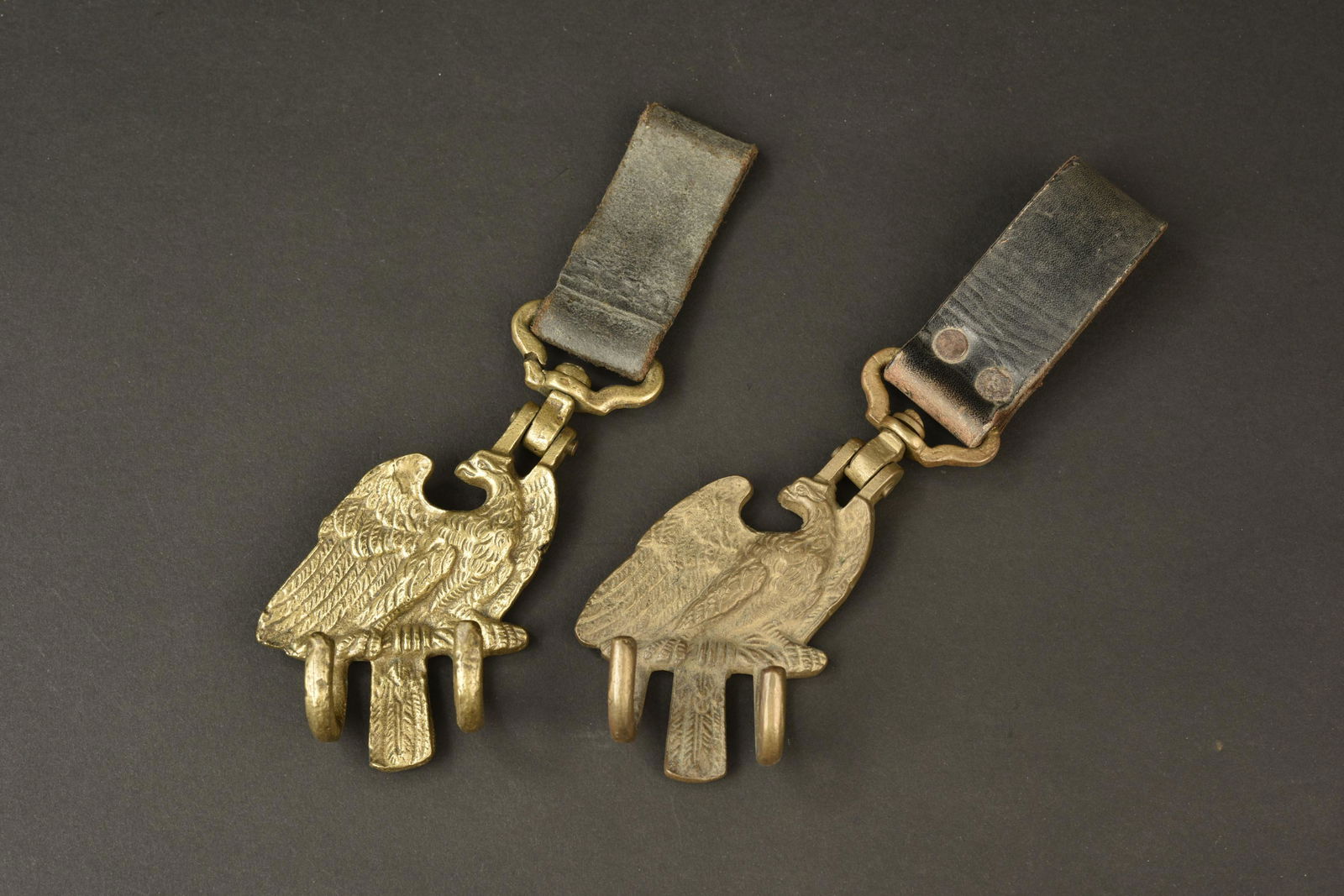 Portes tambour HJ. Hitlerjugend drum holder: Portes tambour Hitlerjugend. Deux pieces en laiton. Les passants en cuir sont presents. Sans marquages visibles. A noter une certaine usure et patine des pieces. Etat II+. Hitlerjugend tambour doors.