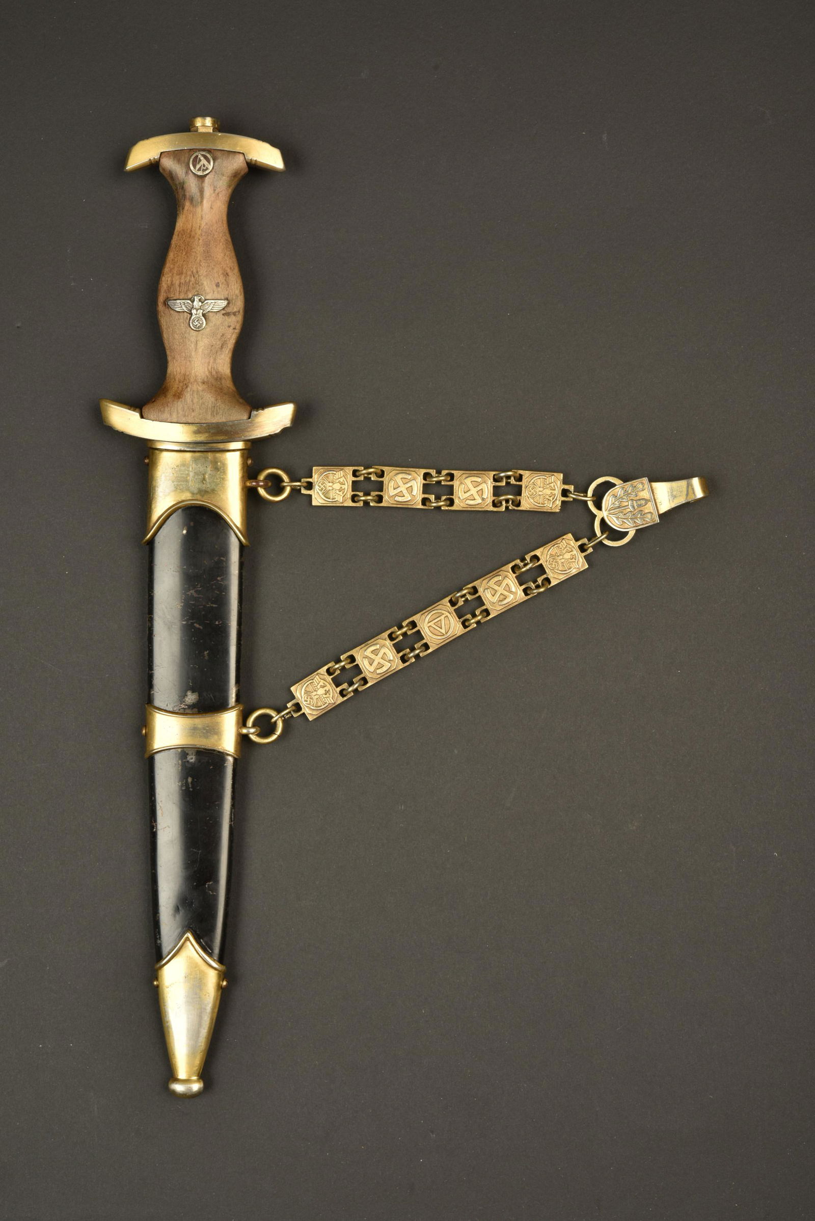 Dague NSKK marine. NSKK Navy Dagger: Dague NSKK marine. Toutes les garnitures sont en metal de couleur dore. Dorure fortement usee. Poignee en bois fortement nettoyee. Insigne SA et aigle remontes. Dague restauree au niveau de la visseri