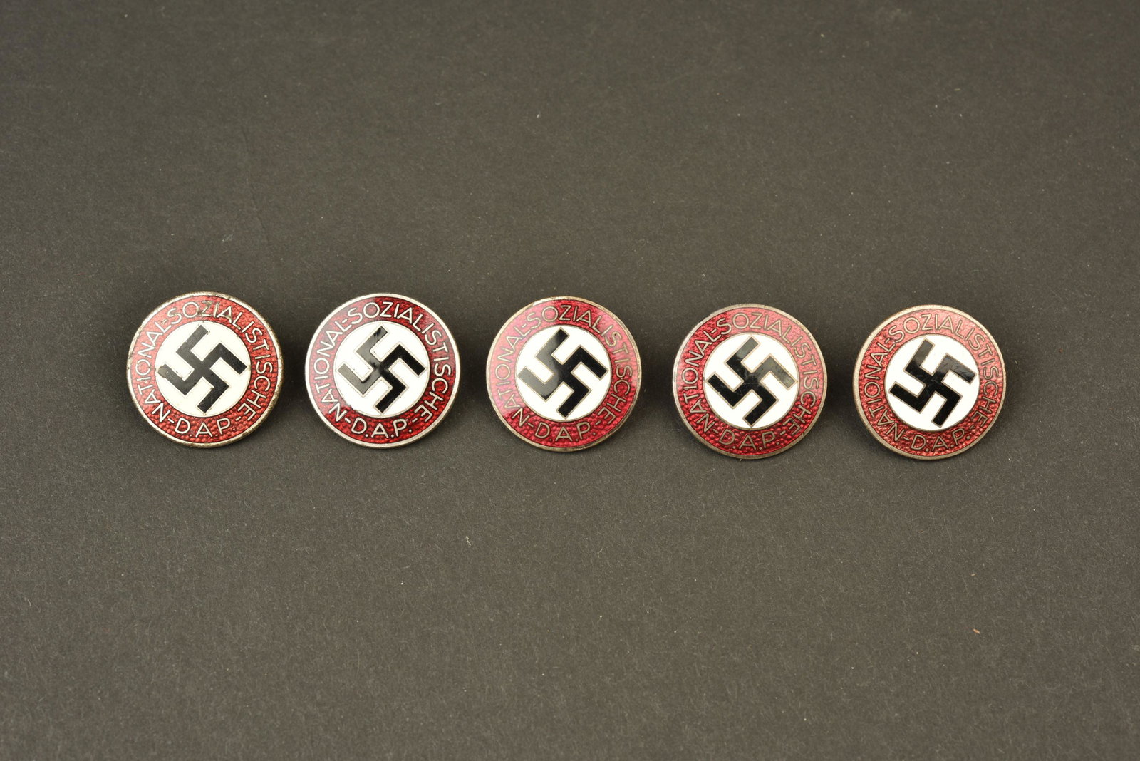 Insignes DAP. DAP insignia: Insignes DAP. Cinq insignes en metal emaille, marques Nationalsozialistische DAP. Toutes les attaches sont presentes. Fabrication RZM M1/103, correspondant a Carl Poellath Schrobenhausen. RZM M1/102, 