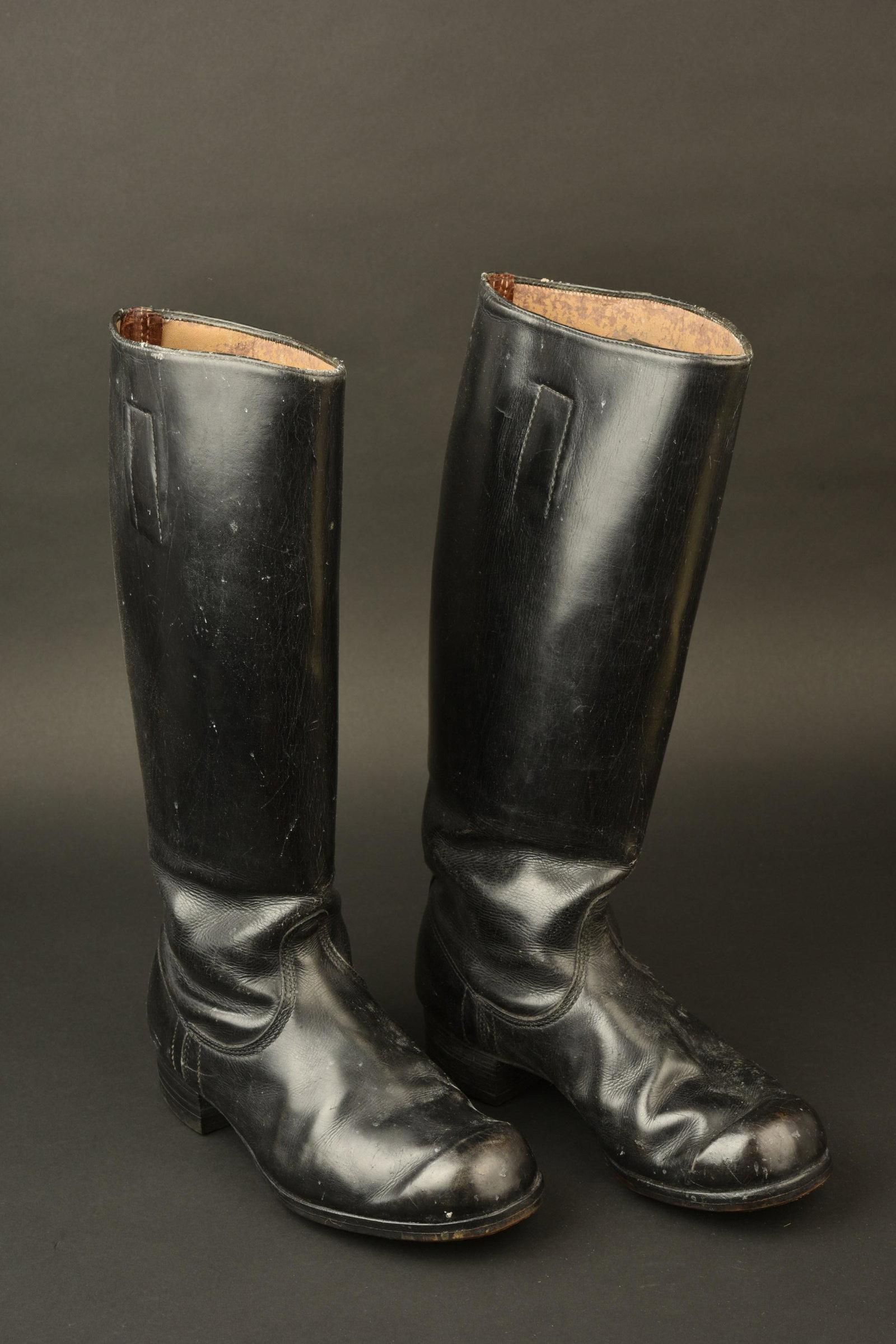 Bottes RZM. RZM Boots: Bottes RZM. Tiges hautes, en cuir noir. Paire homogene. Semelles et talons en caoutchouc. Marquages presents et illisibles. Reste de tampon RZM. Approximativement une pointure 42/43 francaise. A noter
