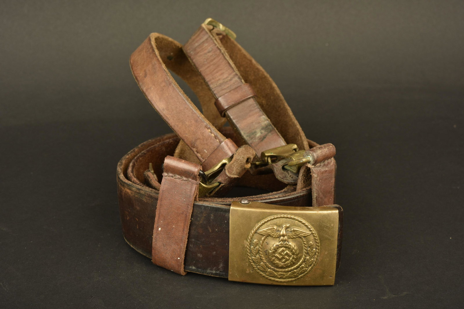 Ceinturon baudrier SA. SA belt: Ceinturon et baudrier SA. Ceinturon en cuir, bouclerie en metal dore, sans marquages visibles. Boucle de ceinturon SA, en metal dore, les ardillons sont presents, sans marquages visibles. Deux passant