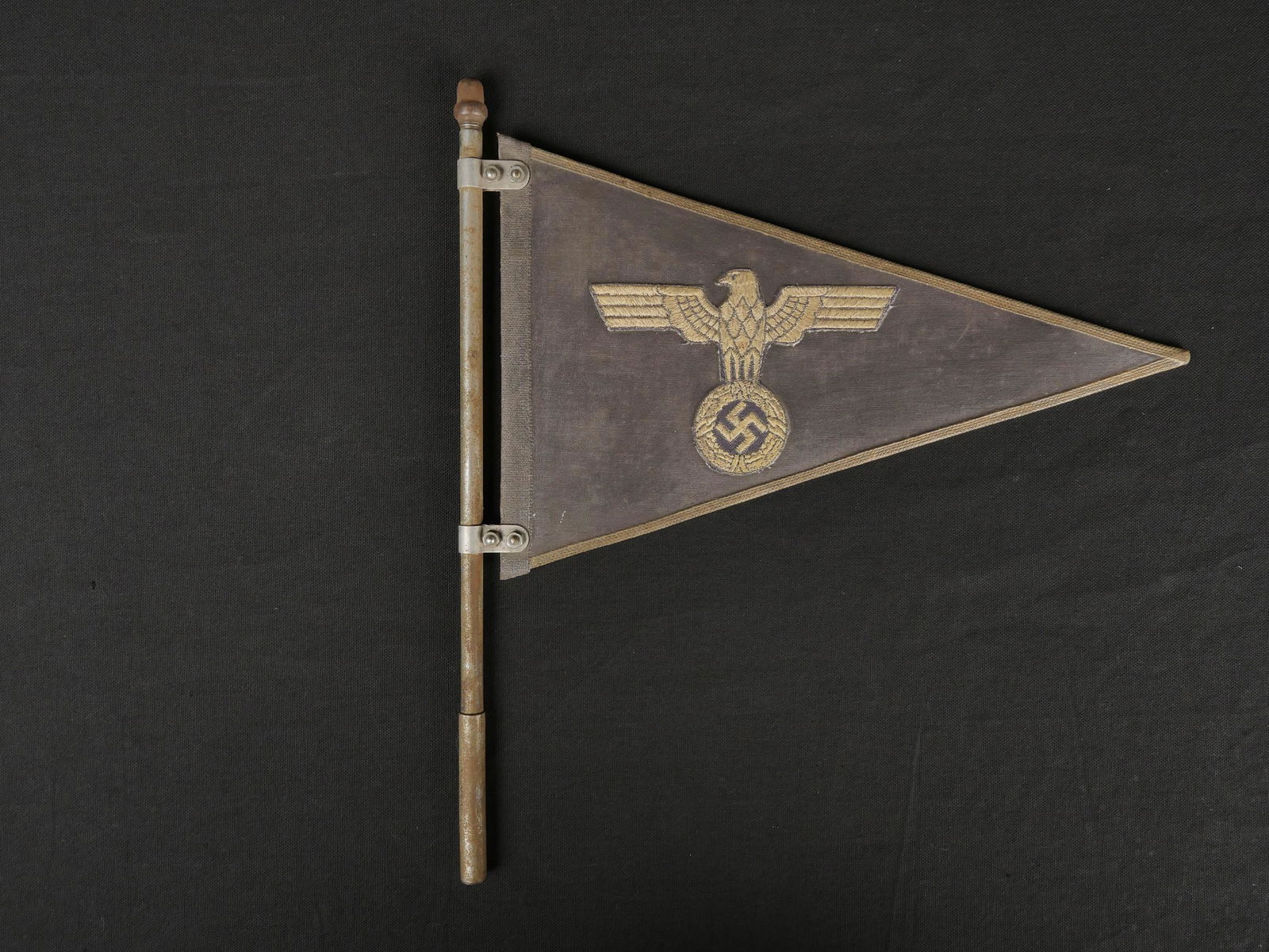 Fanion voiture Heer. Heer Car pennant.: Fanion de voiture de la Heer. En tissu impermeabilise gris. Bordures en fils argentes. Aigles brodes colles sur la surface impermeabilisee. Mat en meta complet, mais presentant quelques marques d oxyd