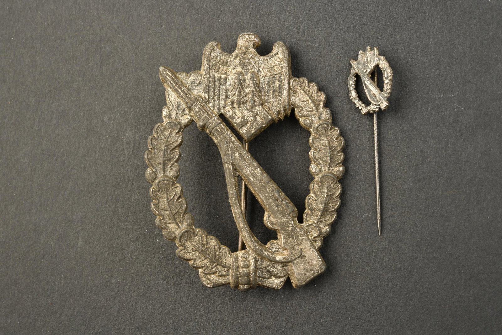 Infanteriekampfabzeichen.: Infanteriekampfabzeichen. En metal, fabrication pleine. Legerement bombee. Oxyde. Couleur argente a 20%. Systeme de fixation complet. On y joint une epinglette de l infanteriekampfabzeichen, sans marq
