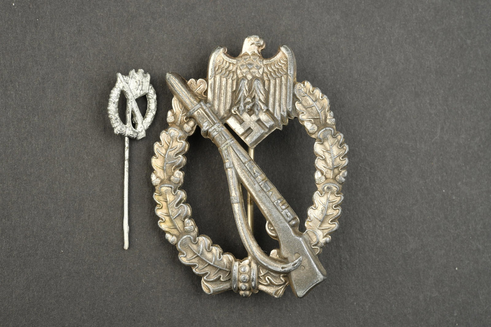 Infanteriekampfabzeichen.: Infanteriekampfabzeichen. En metal, fabrication pleine. Legerement bombee. Oxyde. Couleur argente a 70%. Systeme de fixation complet. On y joint une epinglette de l infanteriekampfabzeichen, incomplet