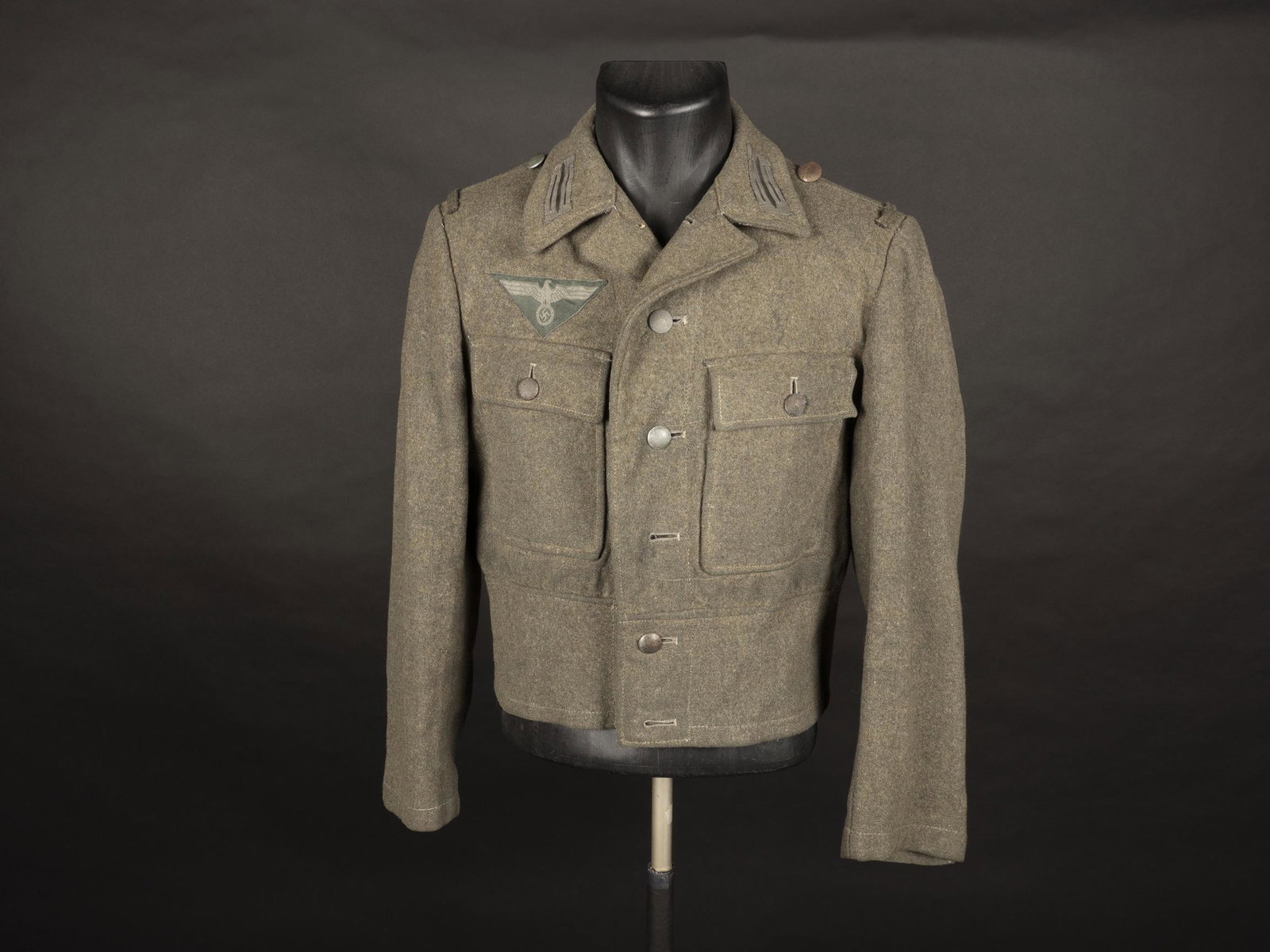 Blouson M-44. M-44 jacket.: Blouson M-44. En drap Feldgrau, la majorite des boutons sont presents. Aigle de poitrine Bevo de forme triangulaire monte machine. Litzen montes d origine. Interieur double en tissu gris. Sans marquag