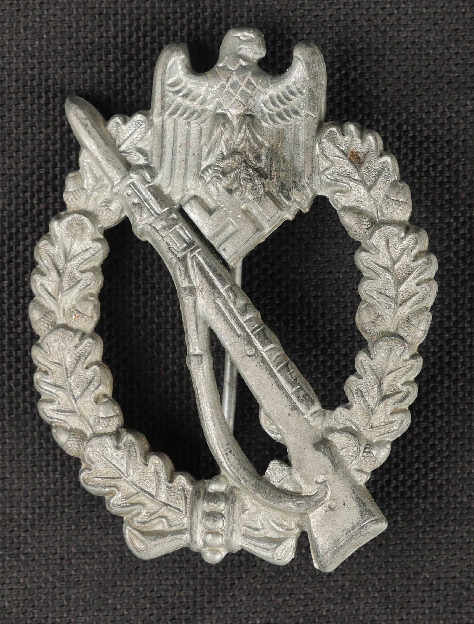 Insigne infanterie. Infantry badge.: Insigne d infanterie. En metal, couleur argent a 80%. Fabrication pleine. Attache complete. Modele legerement bombe. Fabrication FO. A noter une certaine usure et patine de la piece. Etat II+. Plus de