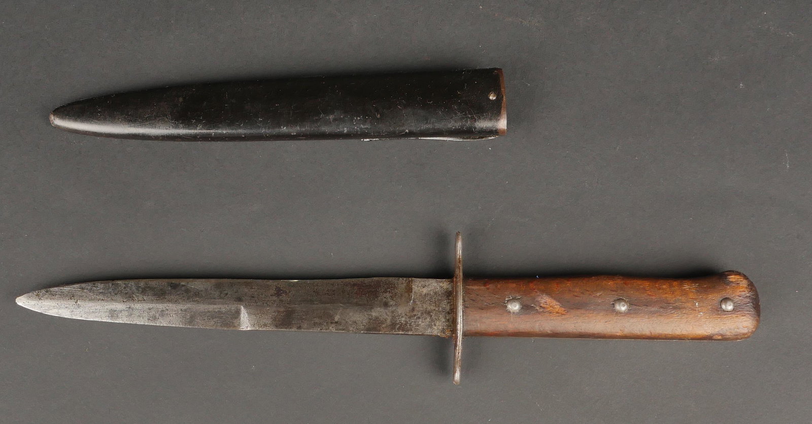 Couteau de botte. Boot knife.: Couteau de botte. Plaquettes en bois, maintenues par trois rivets. Lame presentant des marques d oxydation, sans marquage visible, pointe cassee. Fourreau en metal, peinture a 80%, quelques bosses, at
