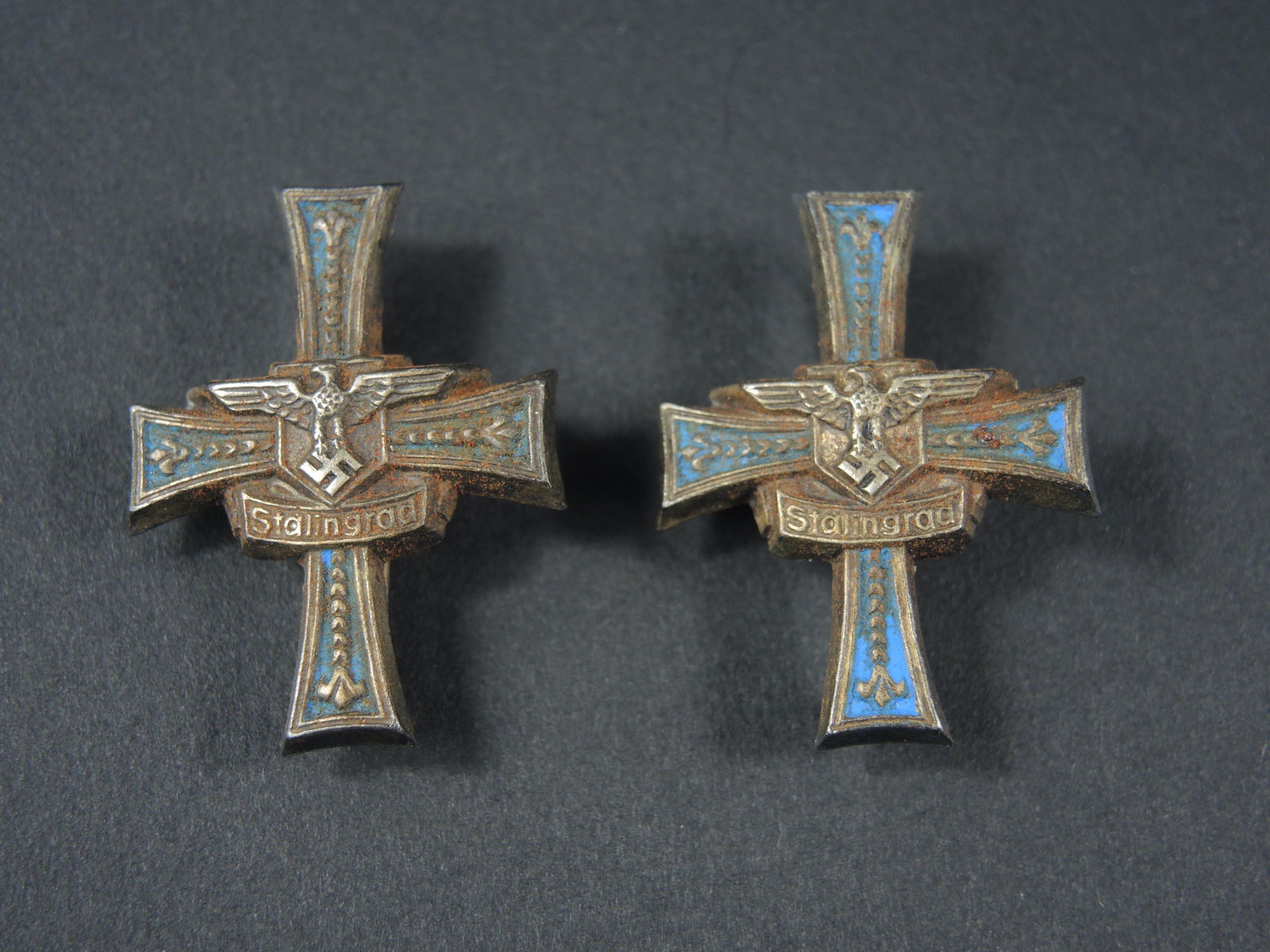 Insignes Stalingrad. Stalingrad Insignia.: Insignes de pattes d epaule Stalingrad. En metal. Paire homogene. Couleur bleue quasiment absente sur un insigne. Les attaches sont presentes. A noter une certaine usure et patine de la piece. Etat II