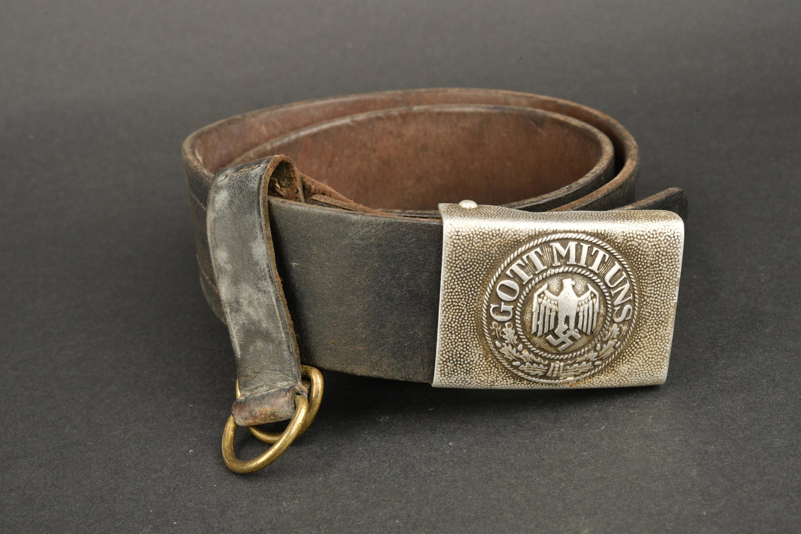 Ceinturon Heer. Heer belt.: Ceinturon de la Heer. Ceinturon en cuir noir, taille 95, les marquages sont illisibles, bouclerie en metal. Un passant de ceinturon present. Une boucle en aluminium grenele, marquages illisibles. Patt