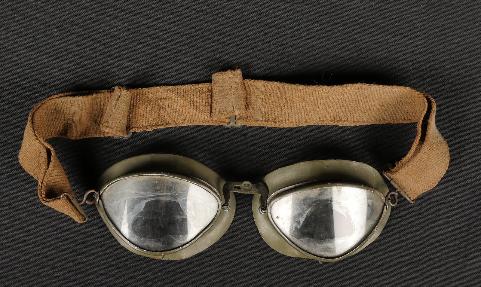 Lunettes de motocycliste. Motorcycle goggles.: Lunettes de motocycliste. Armature en m etal, peinture Feldgrau a 80%. Verres blanc. Doublure en caoutchouc Feldgrau. Marquages MW 40. Elastique sec et distendu. A noter une certaine usure et patine d
