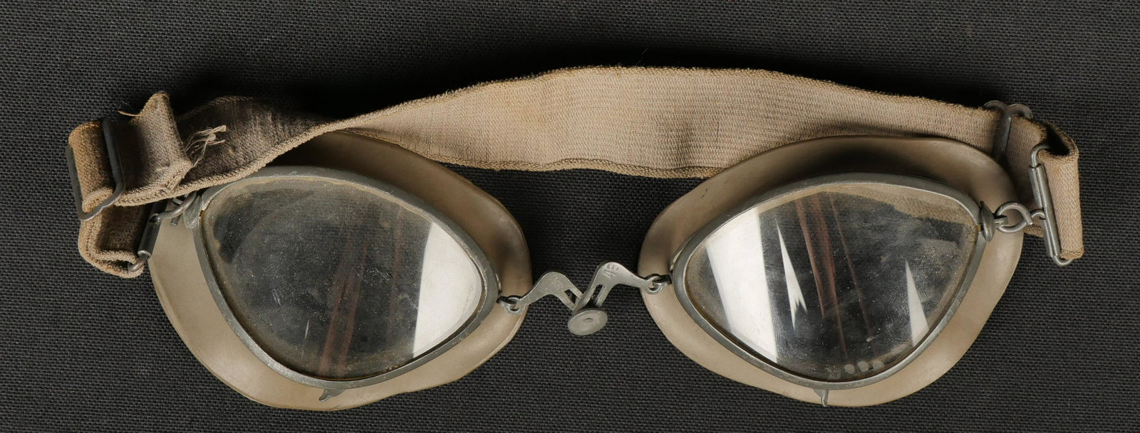 Lunettes motocycliste. Motorcycle goggles.: Lunettes de motocycliste. Armature en m etal, peinture Feldgrau a 80%. Verres blanc. Doublure en caoutchouc Feldgrau. Marquages DetR 43. Elastique sec et distendu. A noter une certaine usure et patine