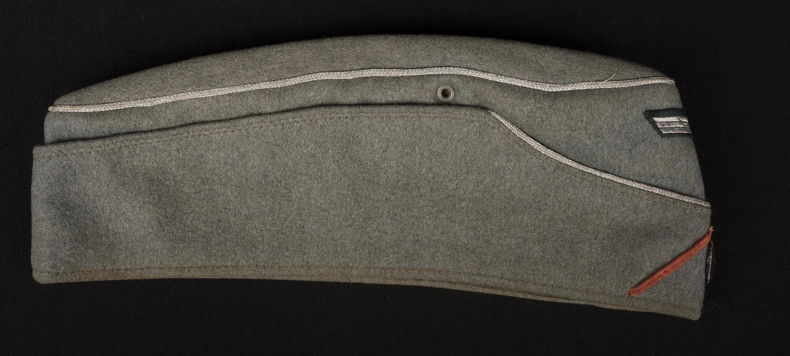 Calot officier Panzer. Panzer officer cap.: Calot d officier Panzer. En drap Feldgrau. Liser e argent faisant le tour de la coiffure. Soutache rose des unit es blind ees. Cocarde en cannetille argent. Aigle Bevo visiblement mont e d origine. In