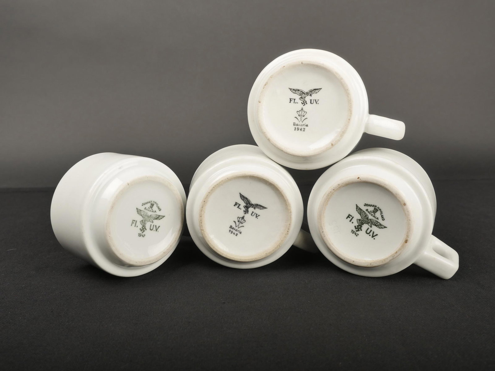 Tasses Luftwaffe. Luftwaffe cups.: Tasses de la Luftwaffe. Quatre tasses en porcelaine blanche, les anses sont pr esentes. Marquages FL UV Bavaria 1942 et Johann Haviland Bavaria 1942. A noter une l eg ere usure et patine des pi eces. 