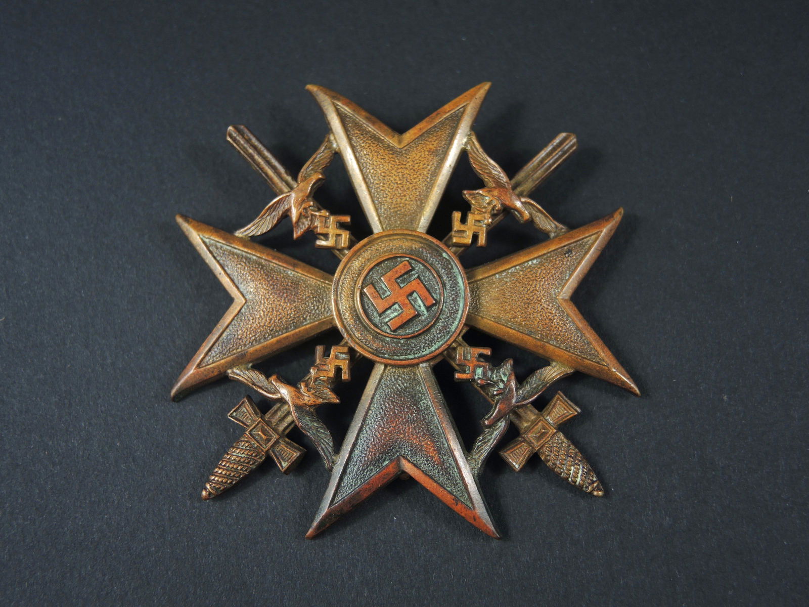 Croix Espagne. Spanien Kreuz.: Spanien Kreuz. Mod ele bronze, avec ep ees. La couleur bronze est pr esente a 70%. Attache compl ete, accroche cass ee. Fabrication CEJ. A noter une certaine usure et patine de la pi ece. Etat II+. Sp