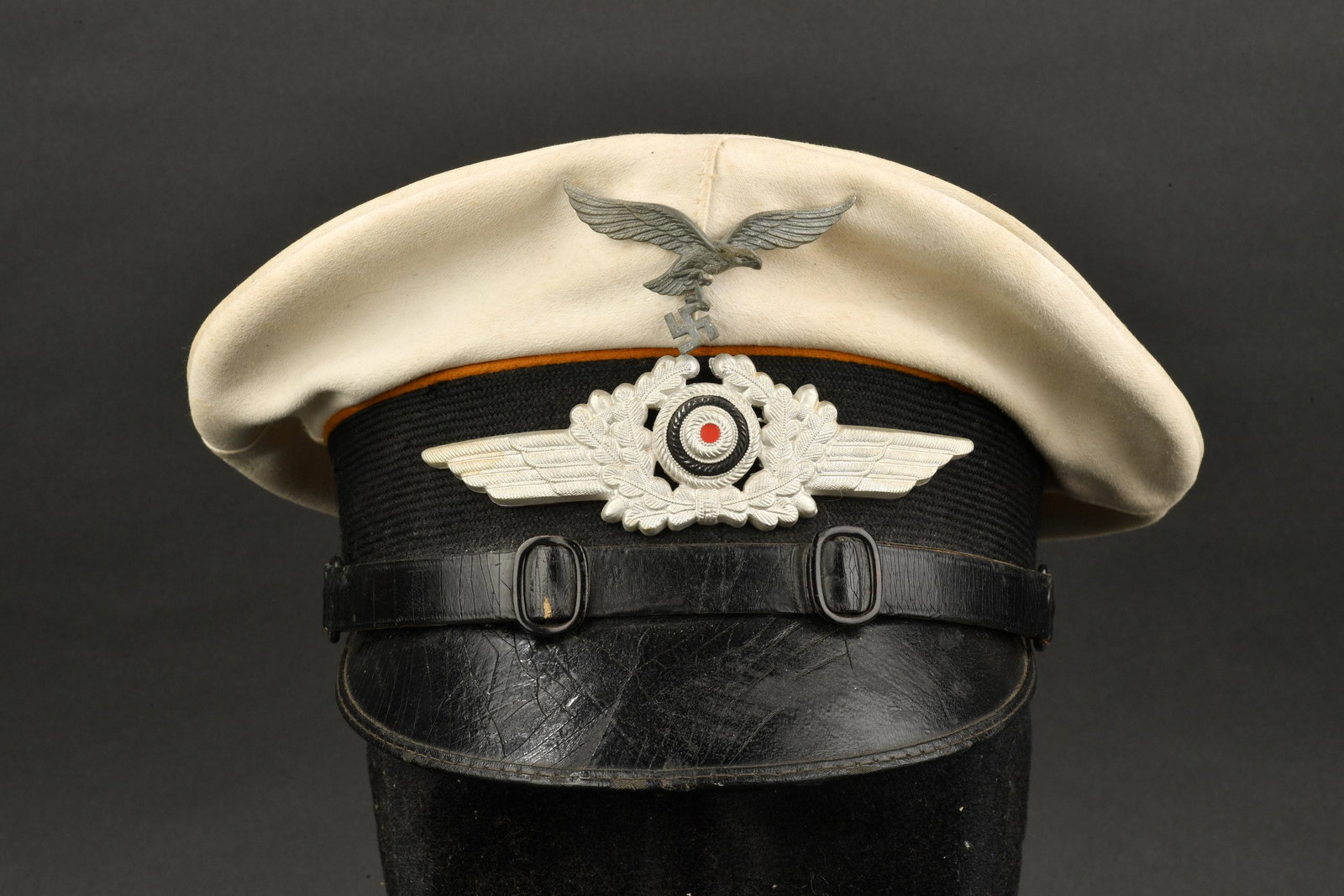 Casquette Luftwaffe. Luftwaffe cap: Casquette de sous-officier Luftwaffe. Reproduction de coiffe blanche amovible. Bandeau en mohair noir. Insignes m etalliques. Les insignes n ont pas et e d emont es afin de v erifier les pattes de fix