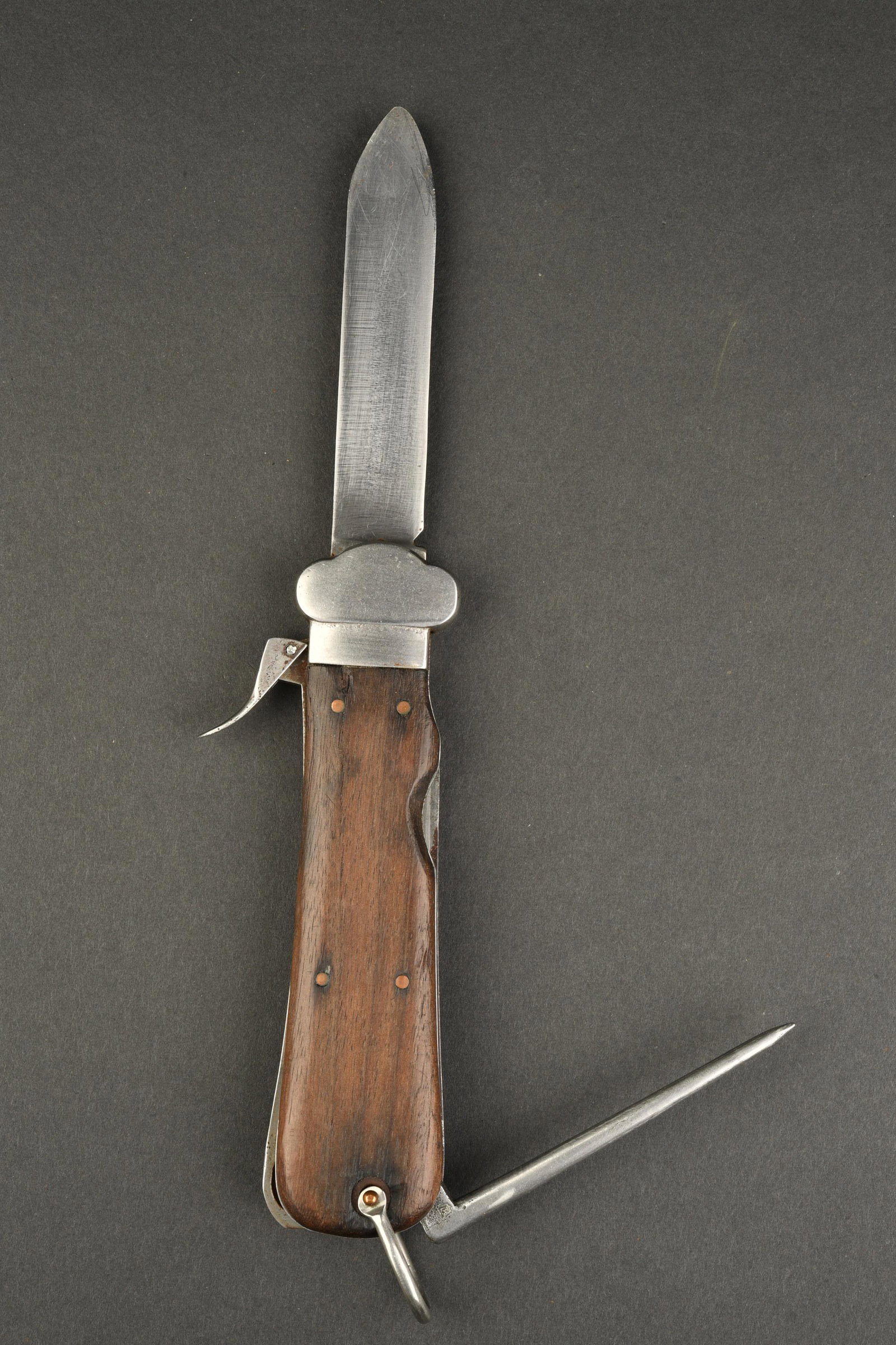 Couteau parachutiste allemand. German paratrooper s knife.: Couteau parachutiste allemand. Plaquettes en bois, maintenues par quatre rivets. Le syst eme de sortie de la lame est fonctionnel. Pique disposant du marquage Luftamt 6. L anneau grenadi ere est compl