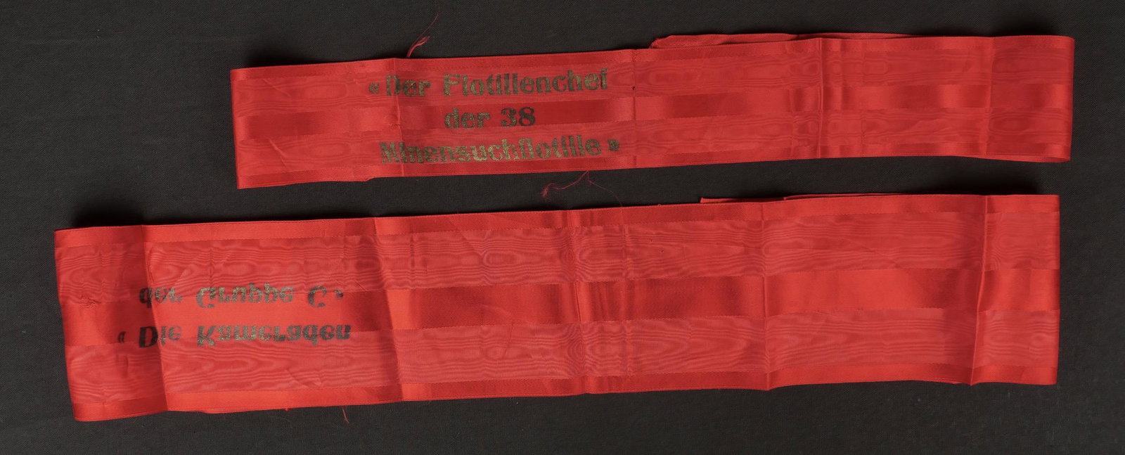 Banderoles Kriegsmarine. Kriegsmarine banners.: Banderoles Kriegsmarine. Une banderole en tissu rouge marqu e Der Flotillenchef der 38 Minensuchflotille, longueur 105 cm. Une banderole en tissu rouge, marqu ee Die Kameraden der Gruppe C, longueur 1