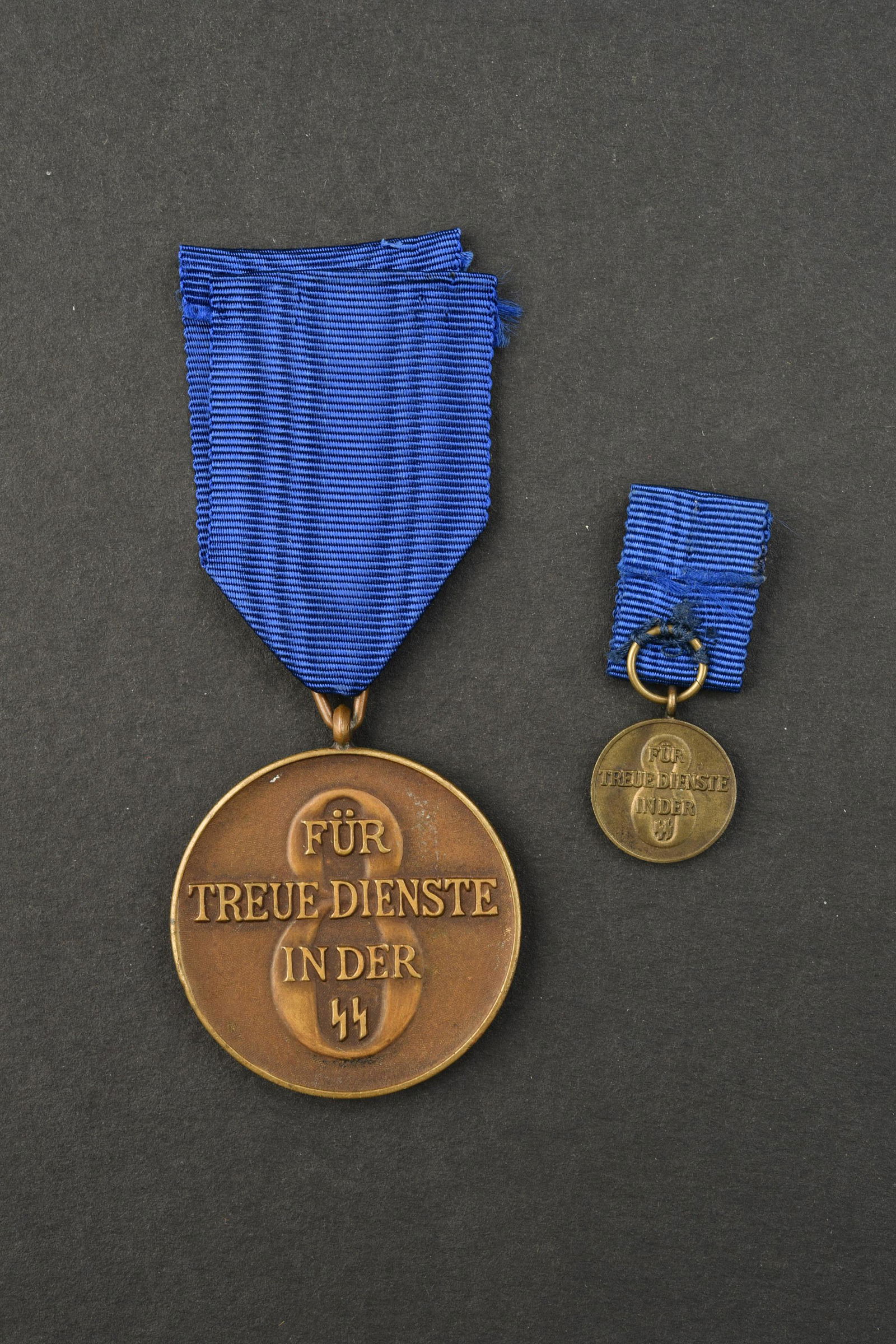 Medaille SS. Waffen SS Medals.: Medaille de 8 ans de service dans la SS. Complete avec son ruban. Medaille miniature pendante presente. A noter une certaine usure et patine de la piece. Etat II+. Medal for 8 years of service in the