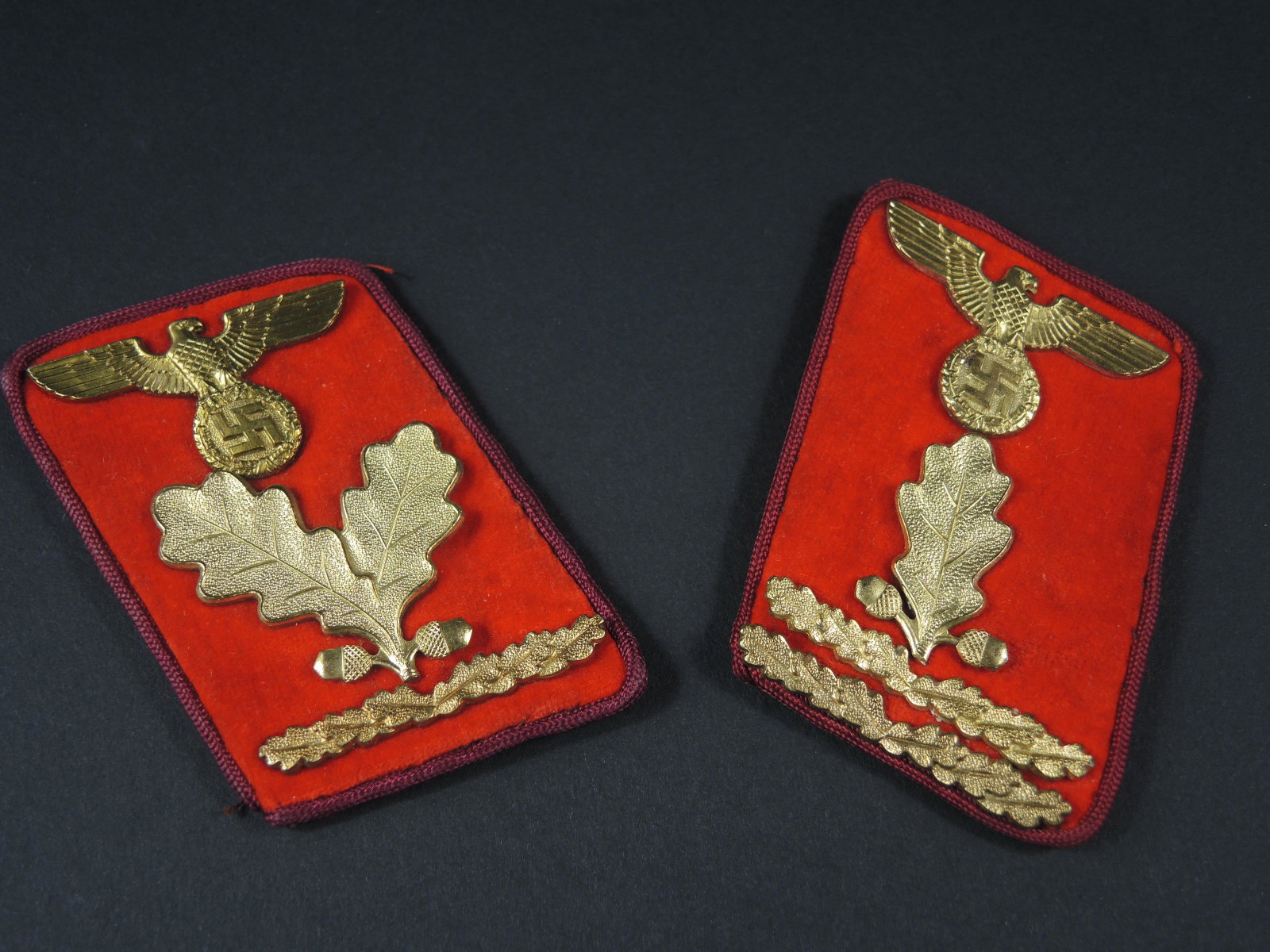 Pattes de col NSDAP. NSDAP collar tabs.: Pattes de col du NSDAP. Paire homogene. En drap rouge. Lisere rouge faisant le tour des pattes de col. Aigles et feuilles de chene metalliques. Les attaches au dos sont presentes. Ces pattes de col so