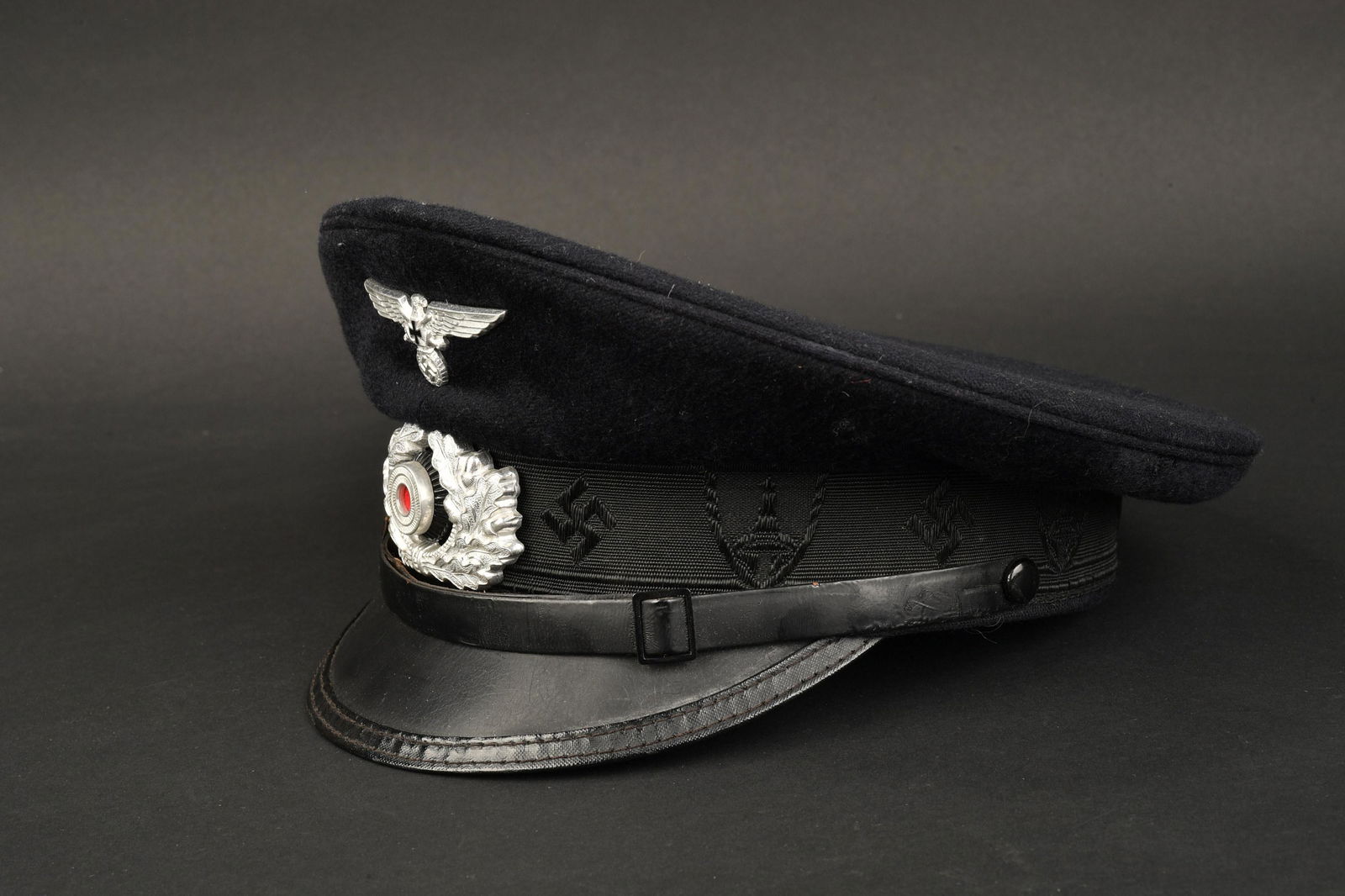 Casquette des anciens combattant. Veteran's cap.: Casquette des anciens combattant. En drap noir. Bandeau disposant d'insignes nationaux et d'insignes du Kyffhauserbund. Aigle cocarde et feuilles de chene en metal couleur argent. Fausse jugulaire pre