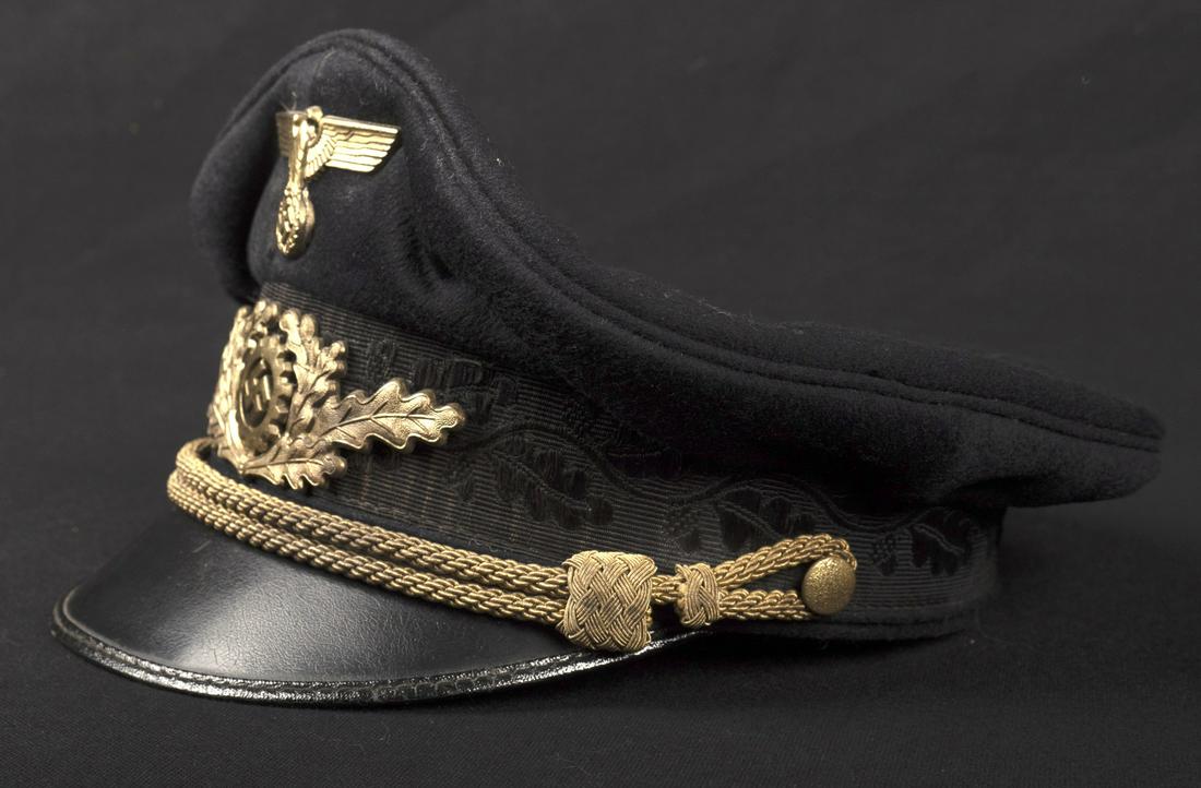 Casquette DAF. German DAF cap: Casquette d'officier superieur du DAF. En drap noir. Bandeau brode de feuilles de chene. Insignes metalliques dores. Les insignes n'ont pas ete demontes afin de verifier les pattes de fixation. Fausse